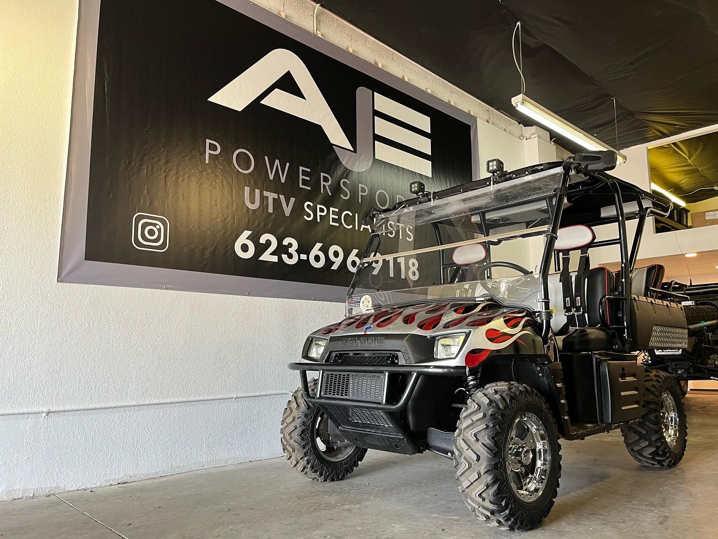 An atv is parked in front of a sign that says powersports atv specialists.