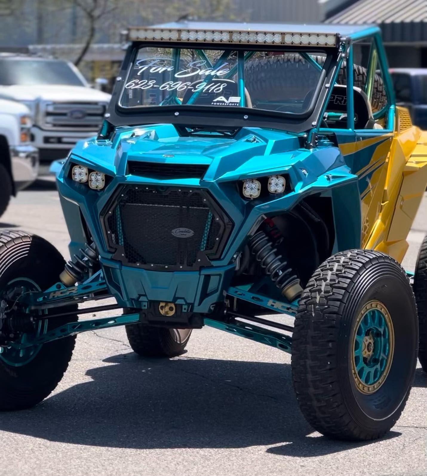 A blue and yellow atv is parked on the side of the road