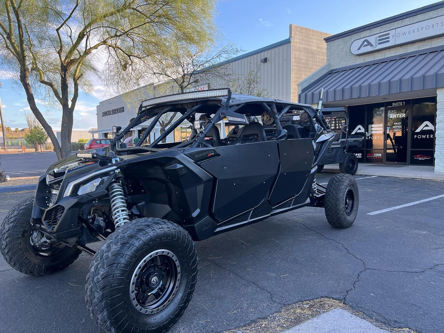 A black can am maverick x3 max is parked in front of a building.