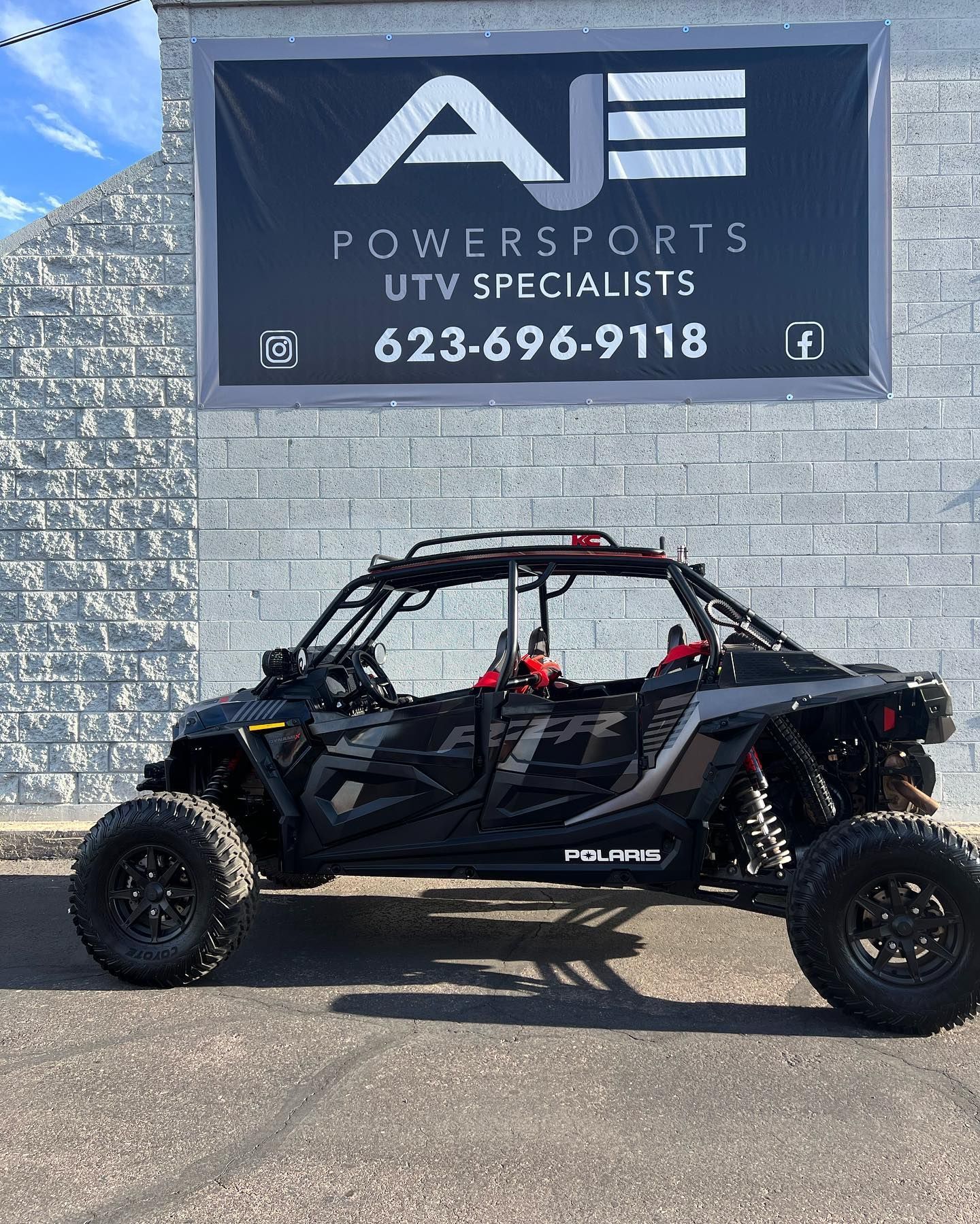 A black atv is parked in front of a wall.
