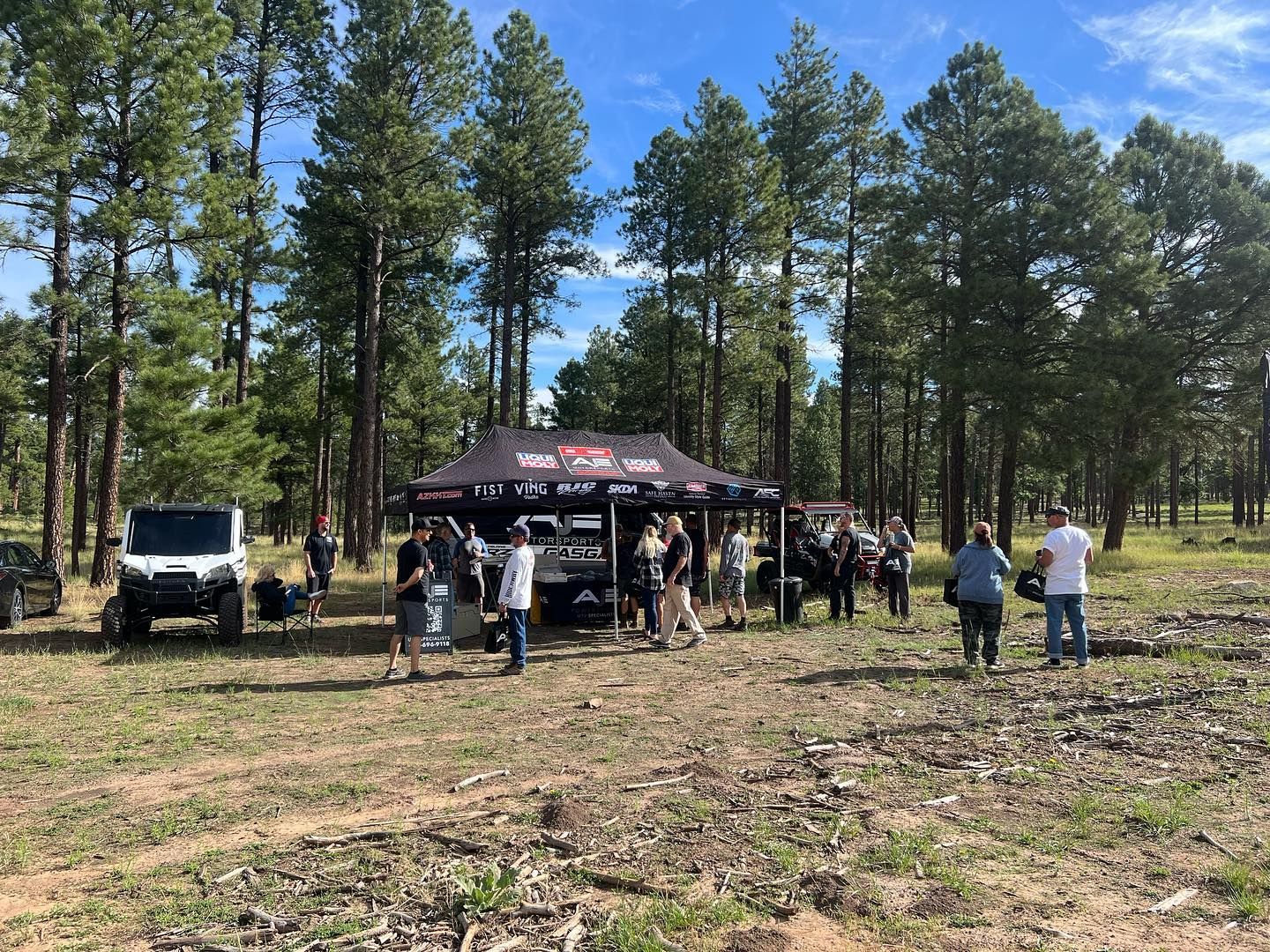 A group of people are standing in a field in front of a tent.