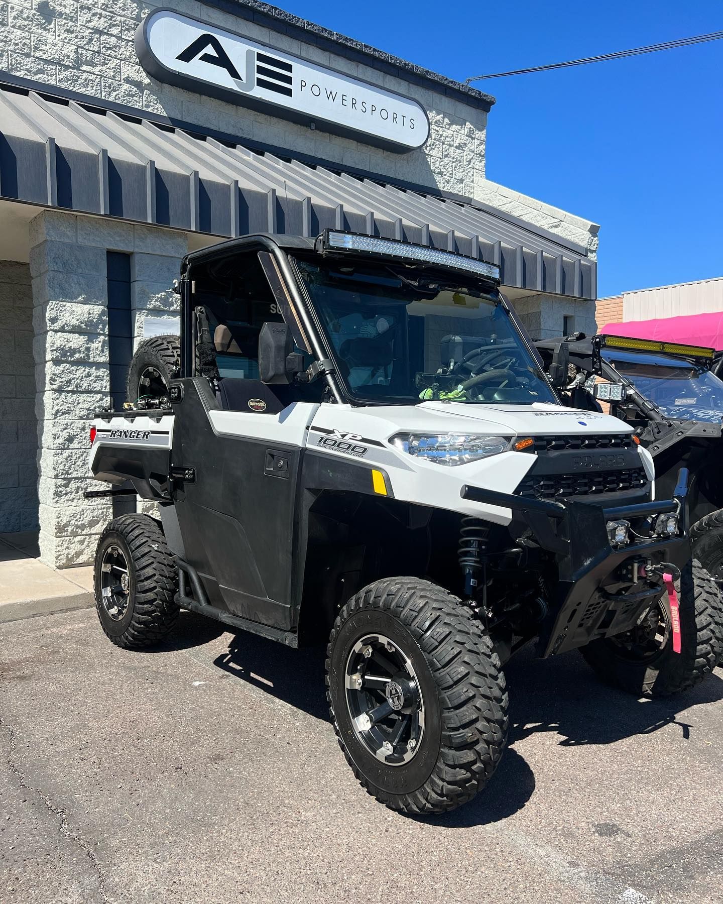 A white atv is parked in front of a building.