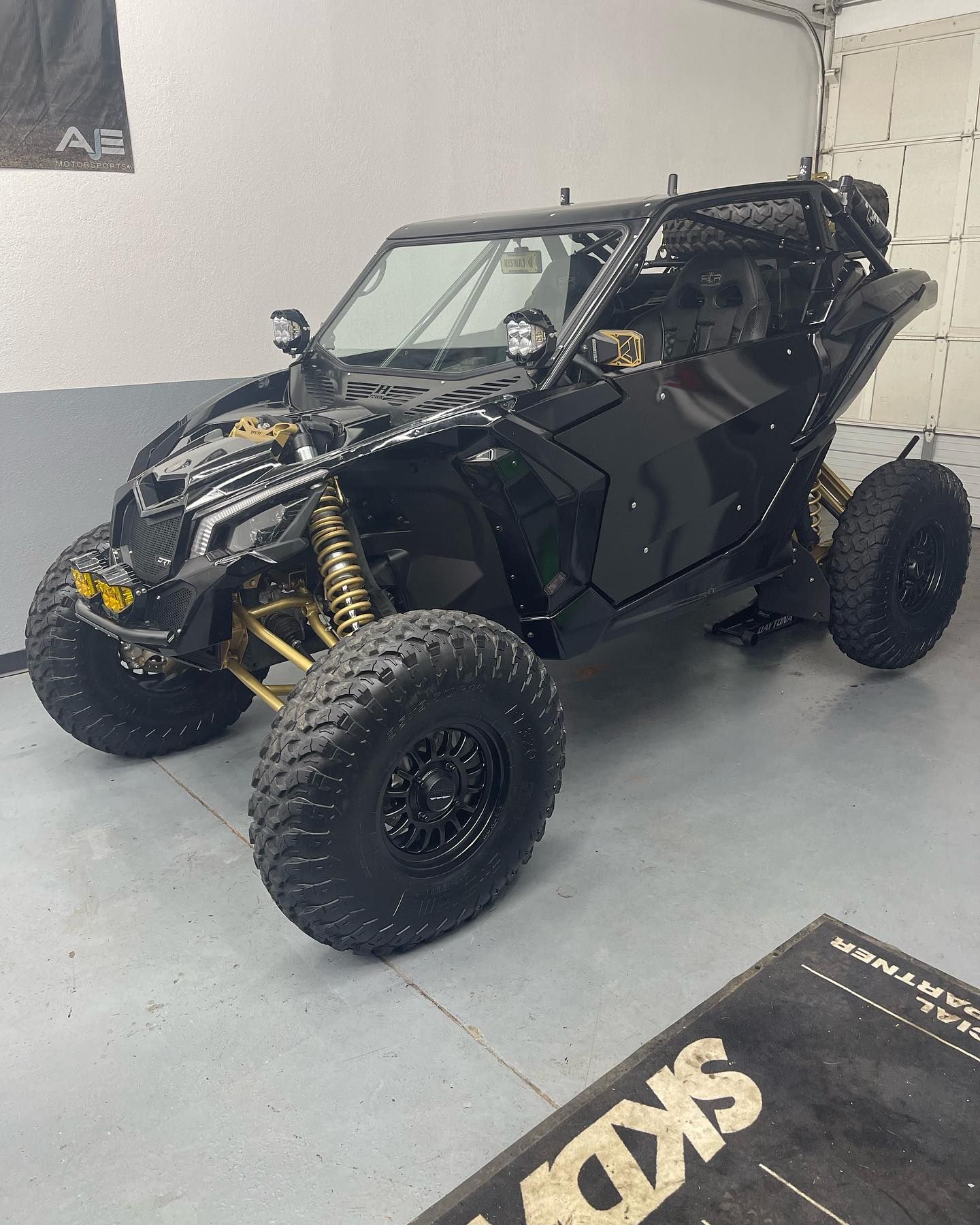 A black and gold atv is parked in a garage.