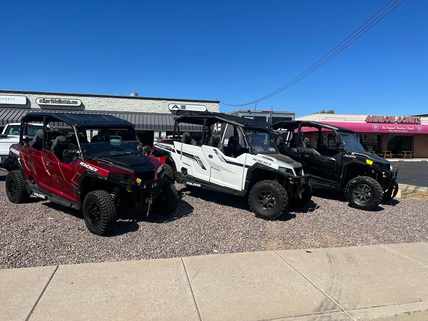 Three atvs are parked in front of a building.