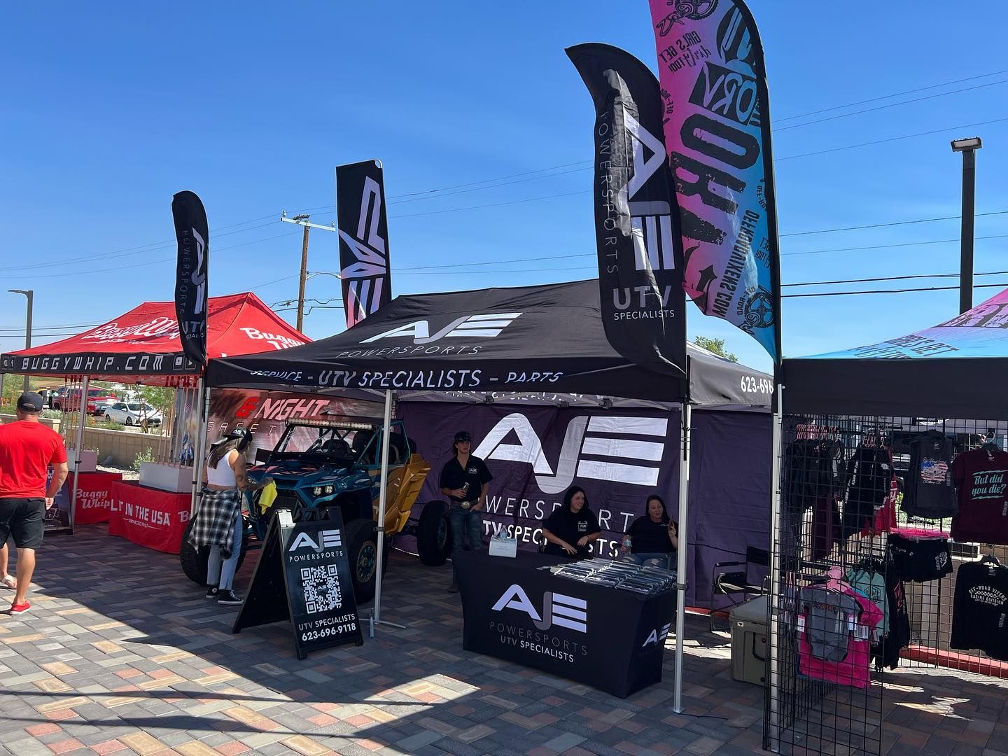 A group of people sitting under a tent that says ae on it