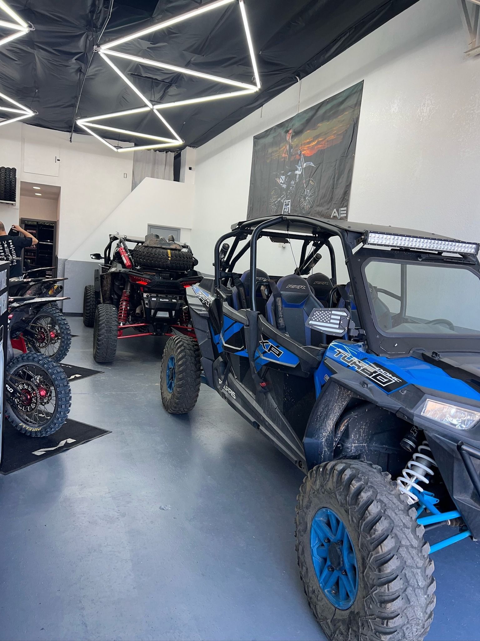 A couple of atvs are parked in a garage.