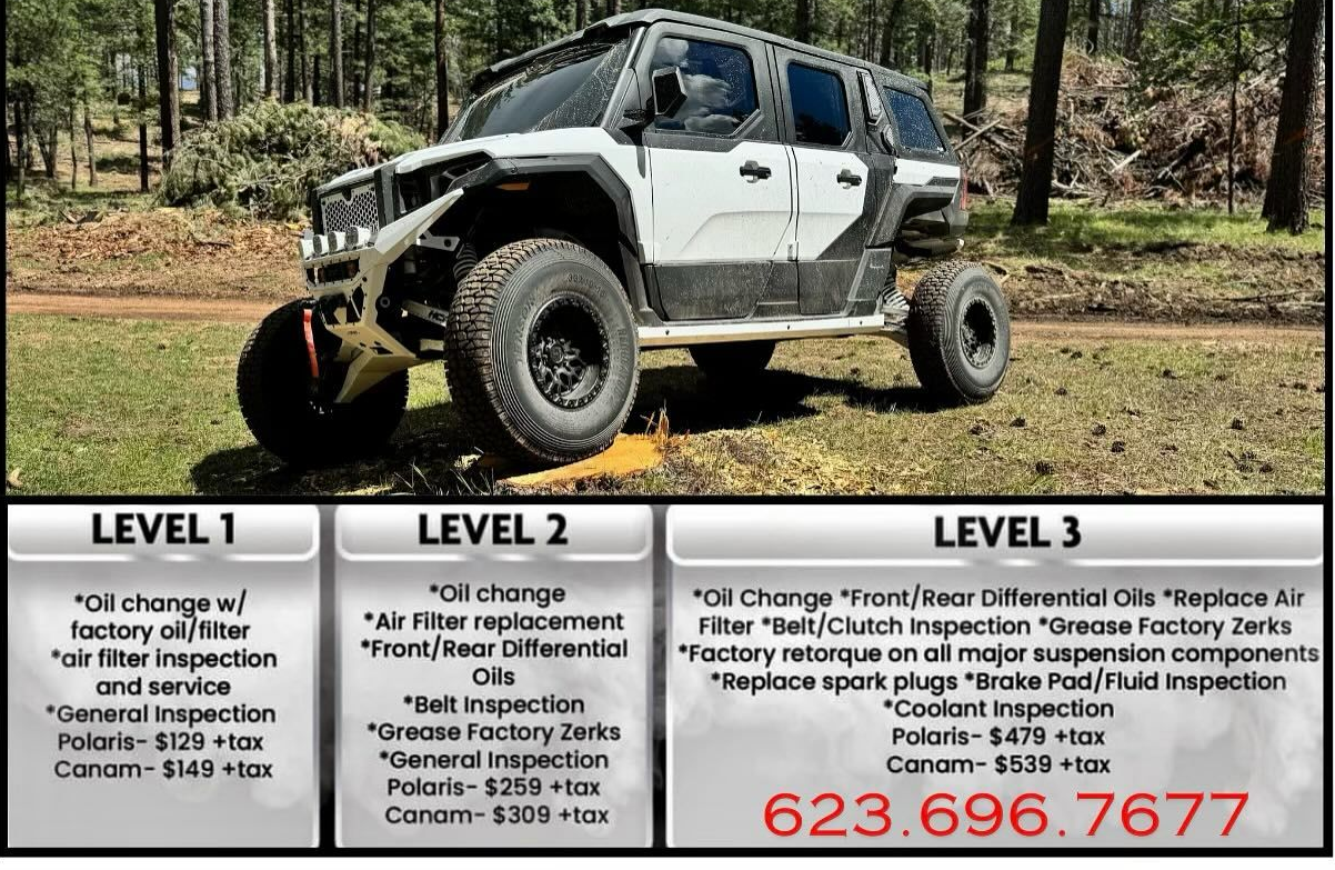 A white suv is parked in the middle of a forest.