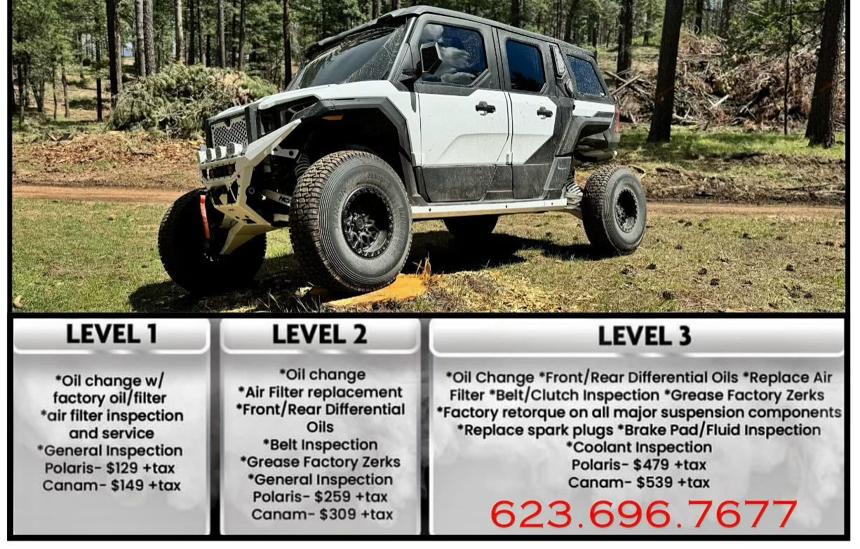 A white suv is parked in the middle of a forest.