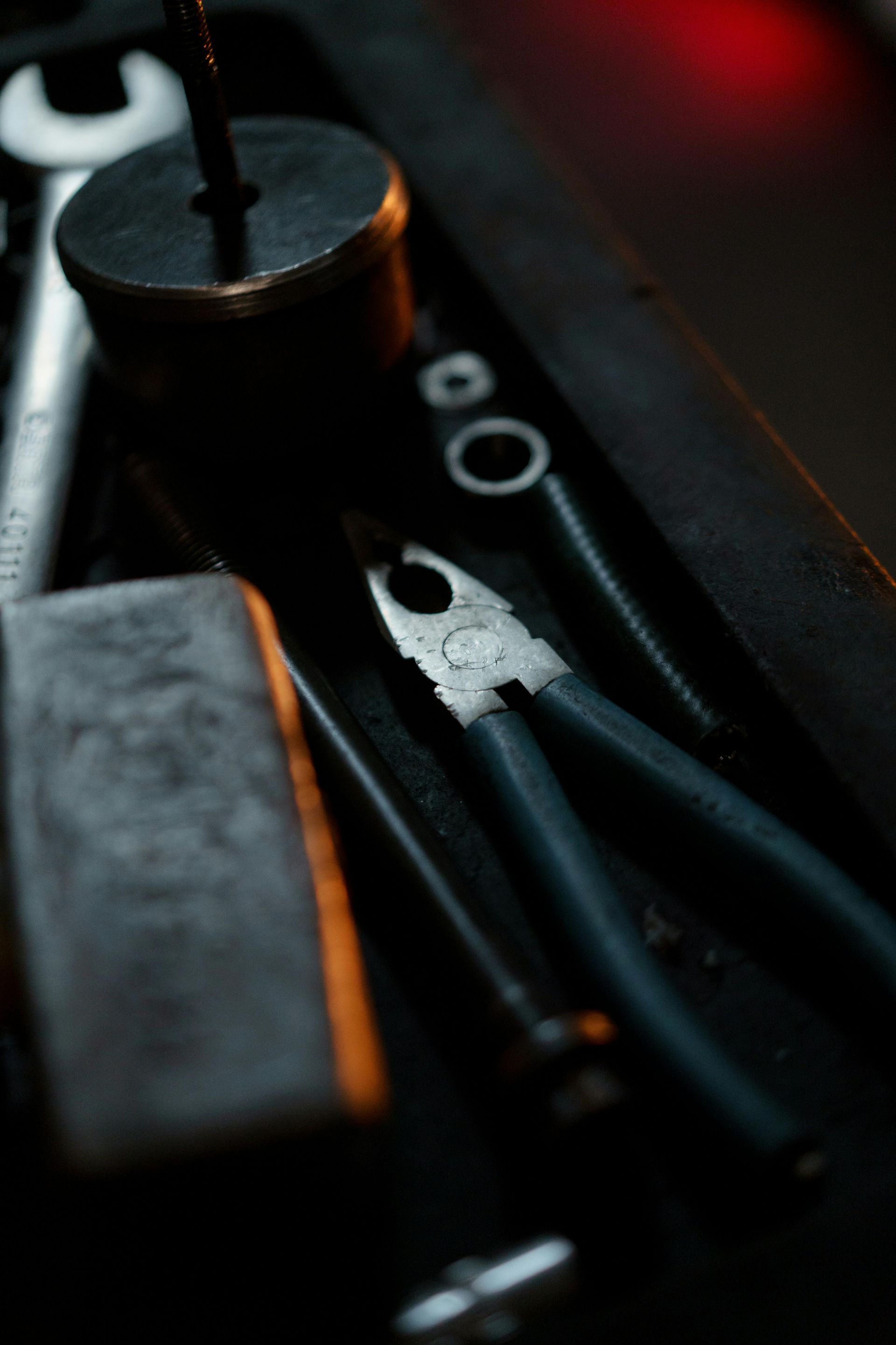 A close up of a pair of pliers and a wrench on a table