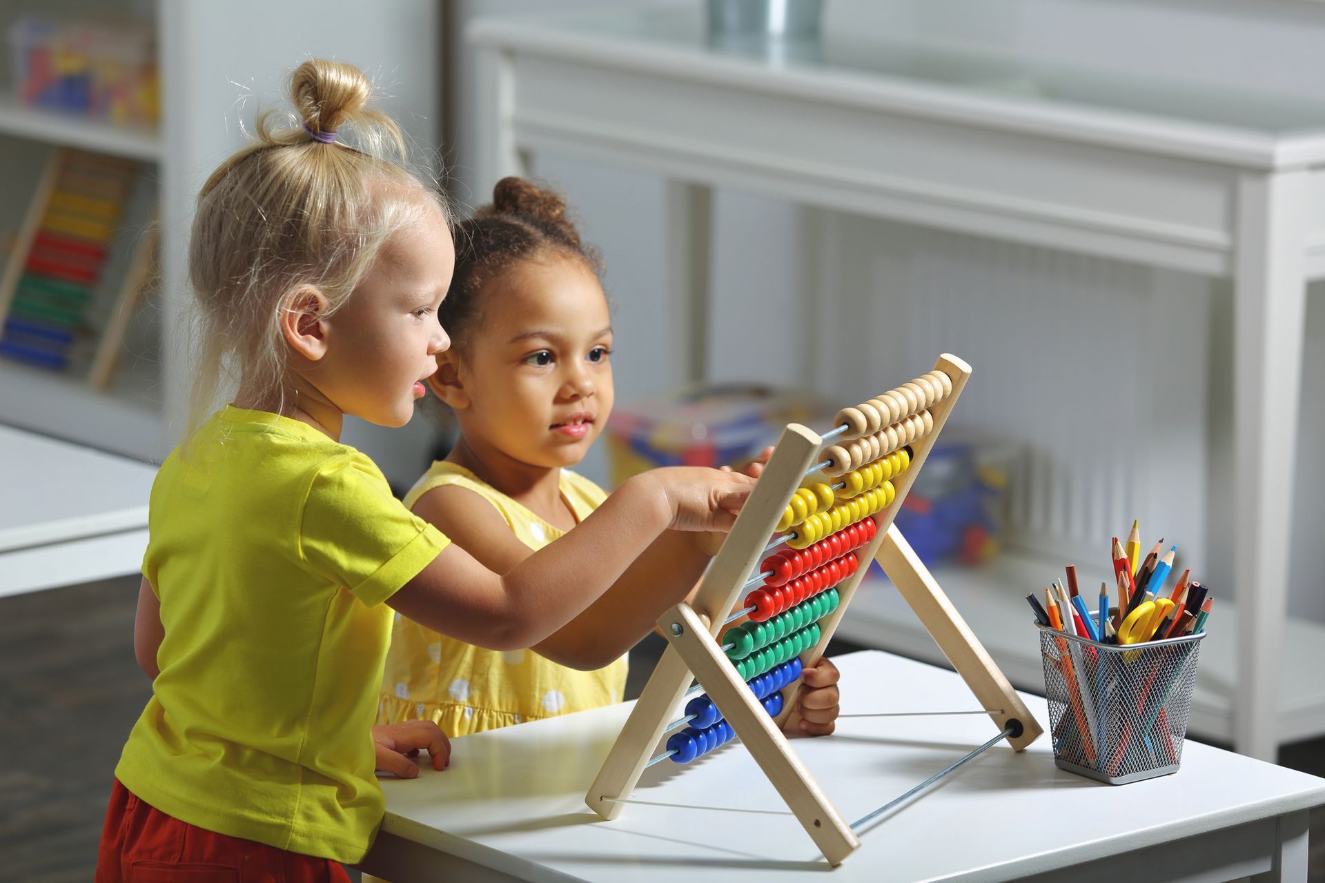 Children together at the table counting on the abacus.