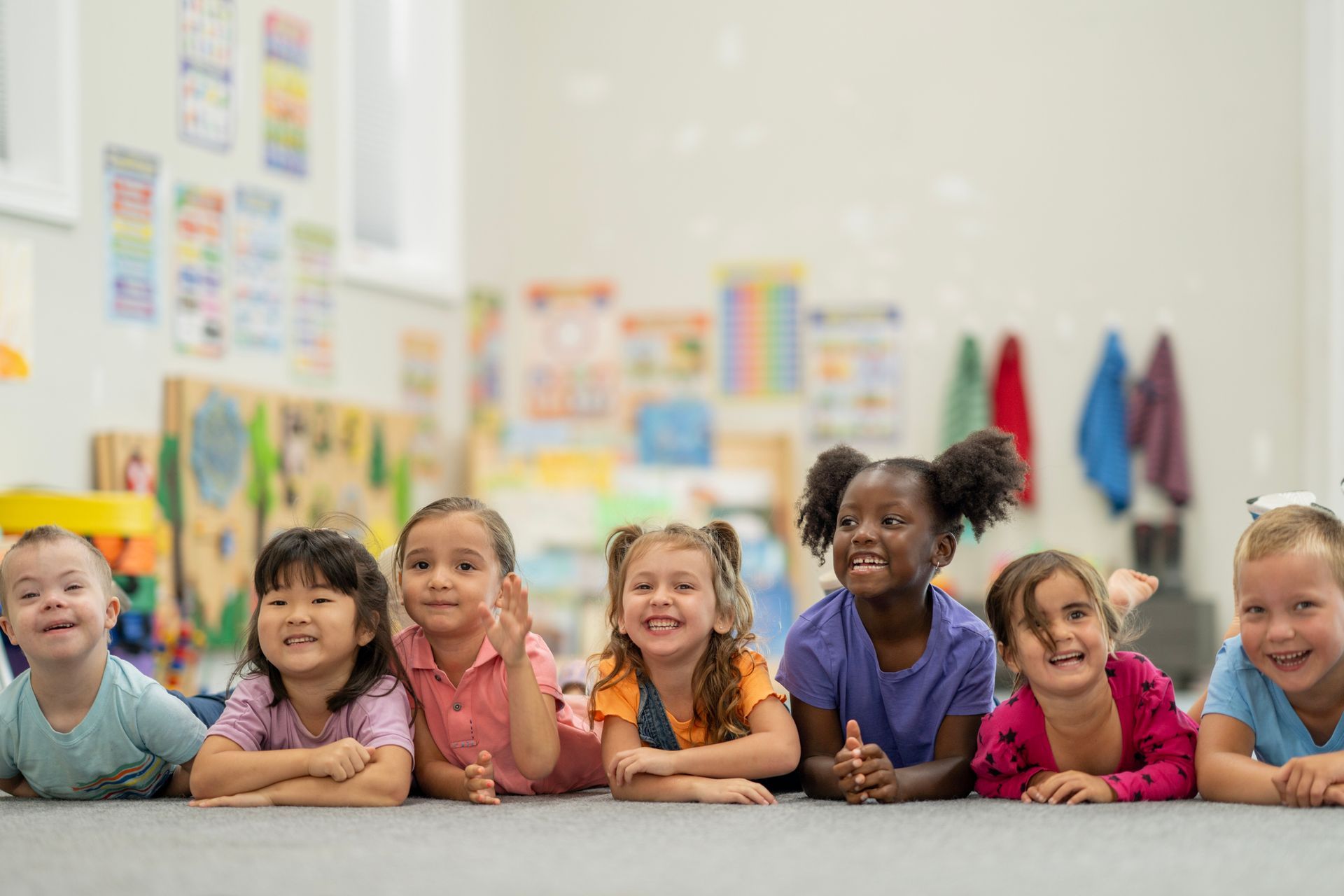A group of children of diverse backgrounds are smiling.