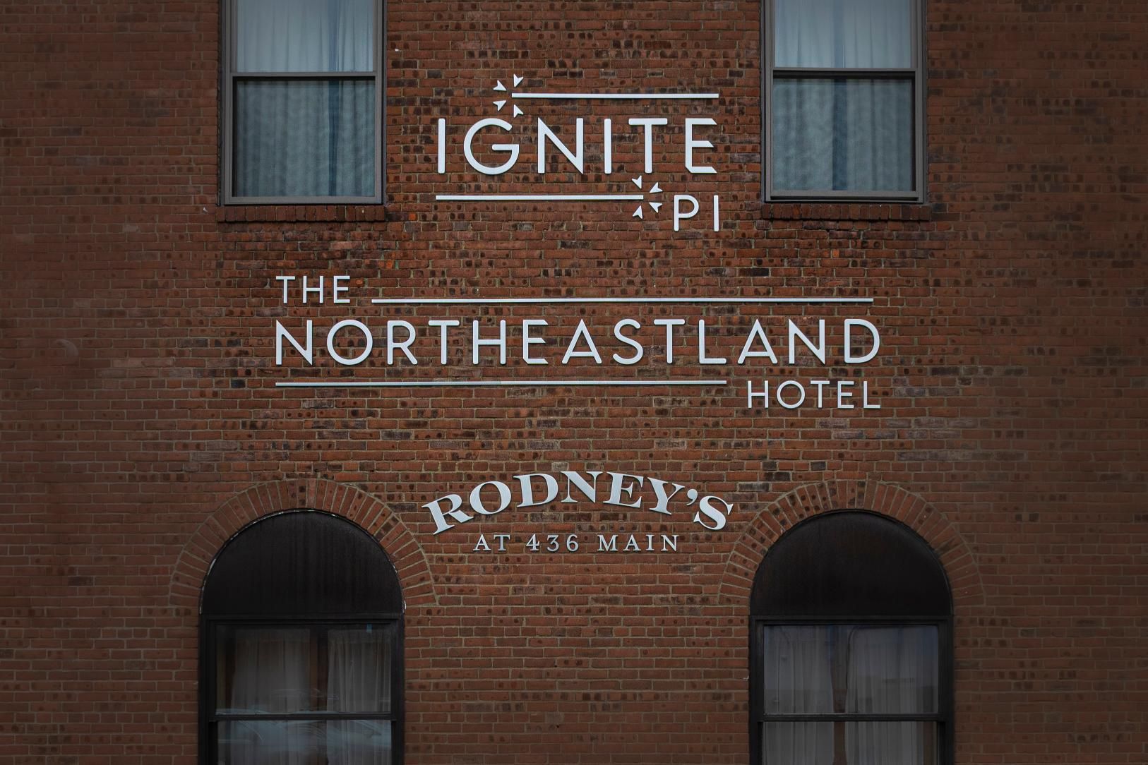 A brick building with a sign that says the northeastland hotel