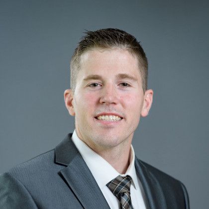 A man in a suit and tie is smiling for the camera.