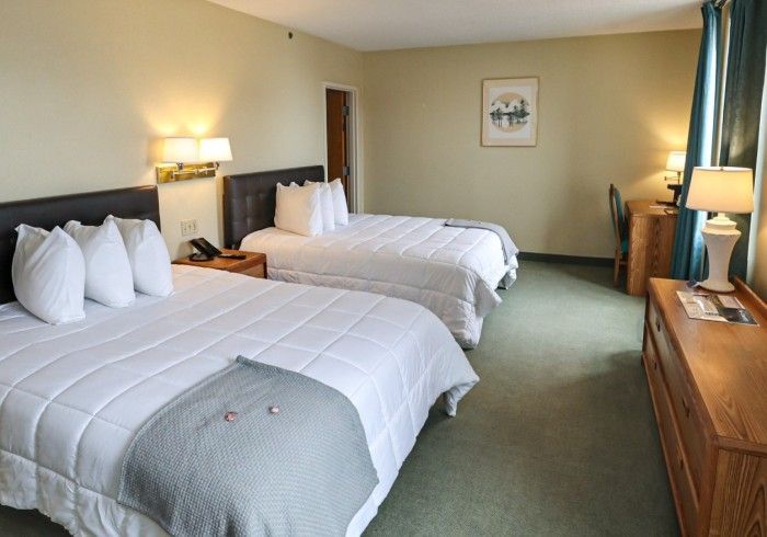 A hotel room with two beds and a desk