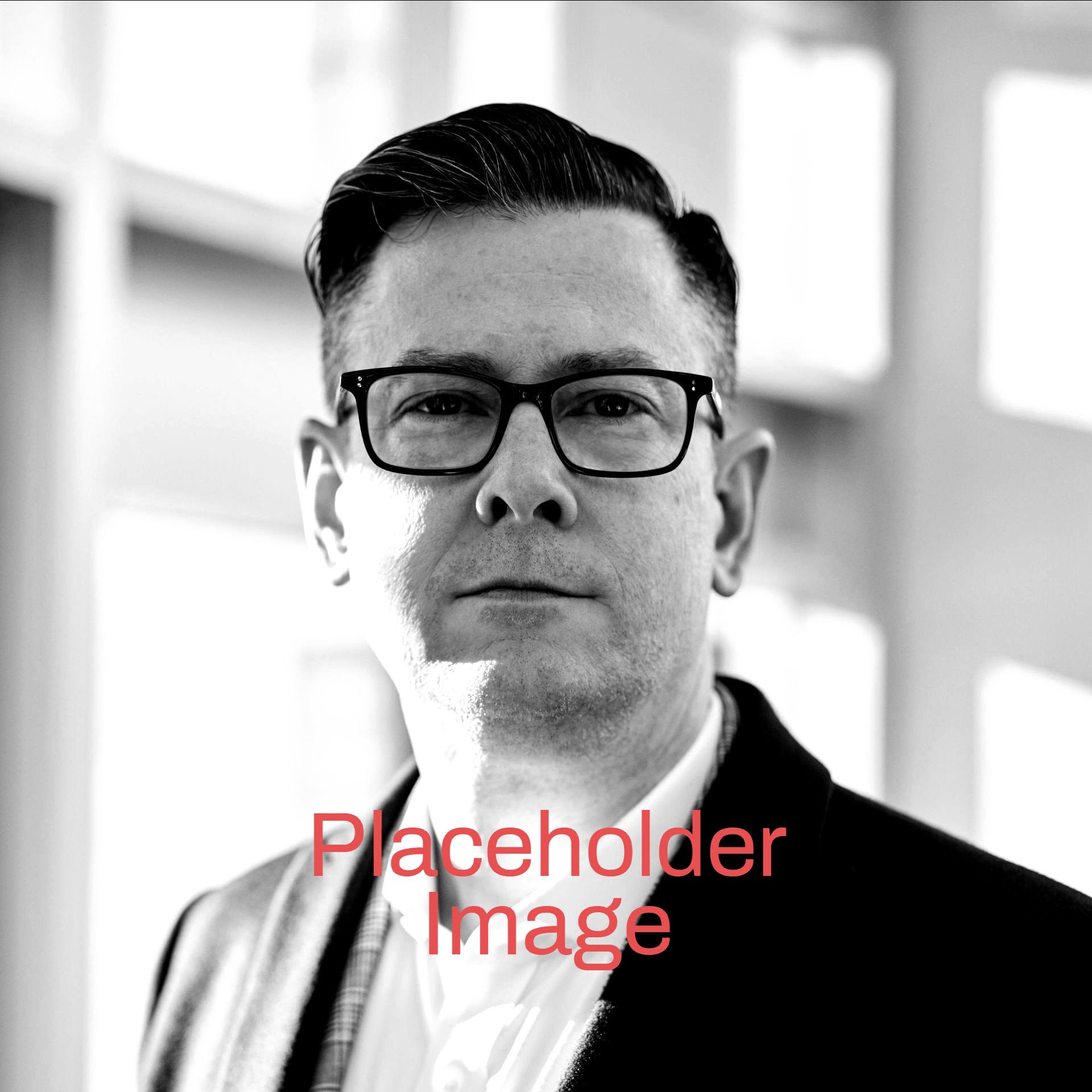 A black and white photo of a man wearing glasses