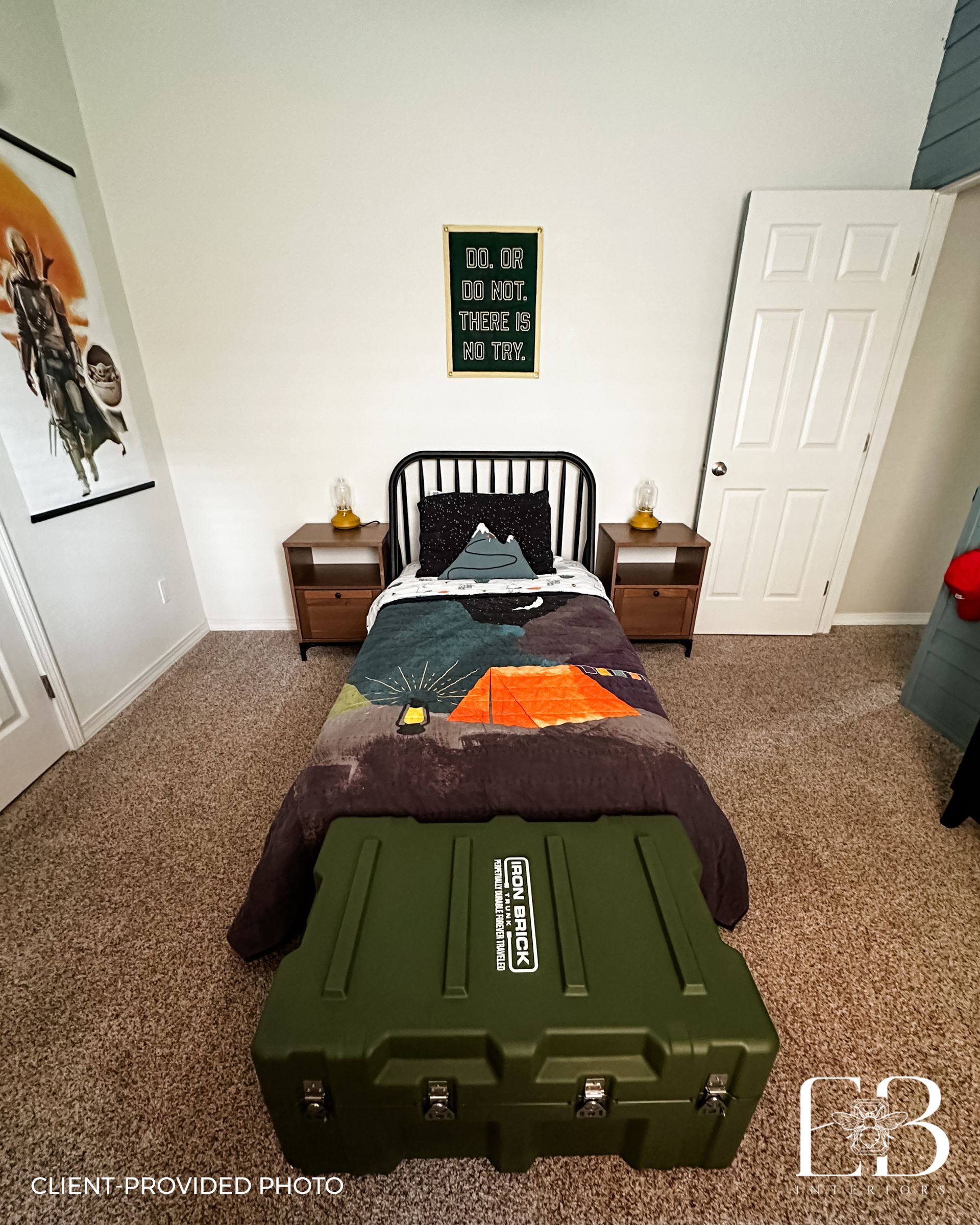 Bedroom with twin bed, mountain-themed bedding, nightstands, green trunk at the foot, and artwork.