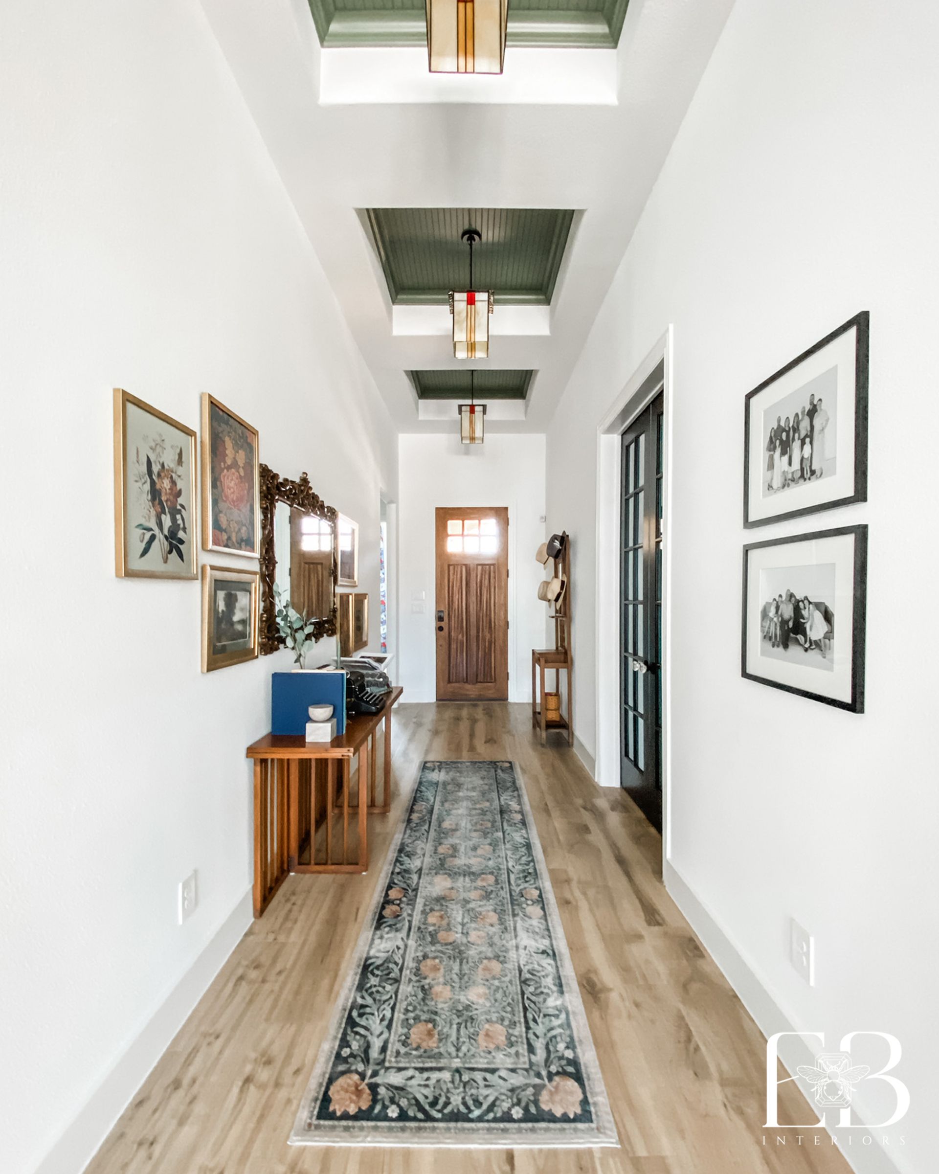 Entry vignette with green wall, vintage furniture, and mirror—Devotion Row New Construction by Emerald Bee Interiors