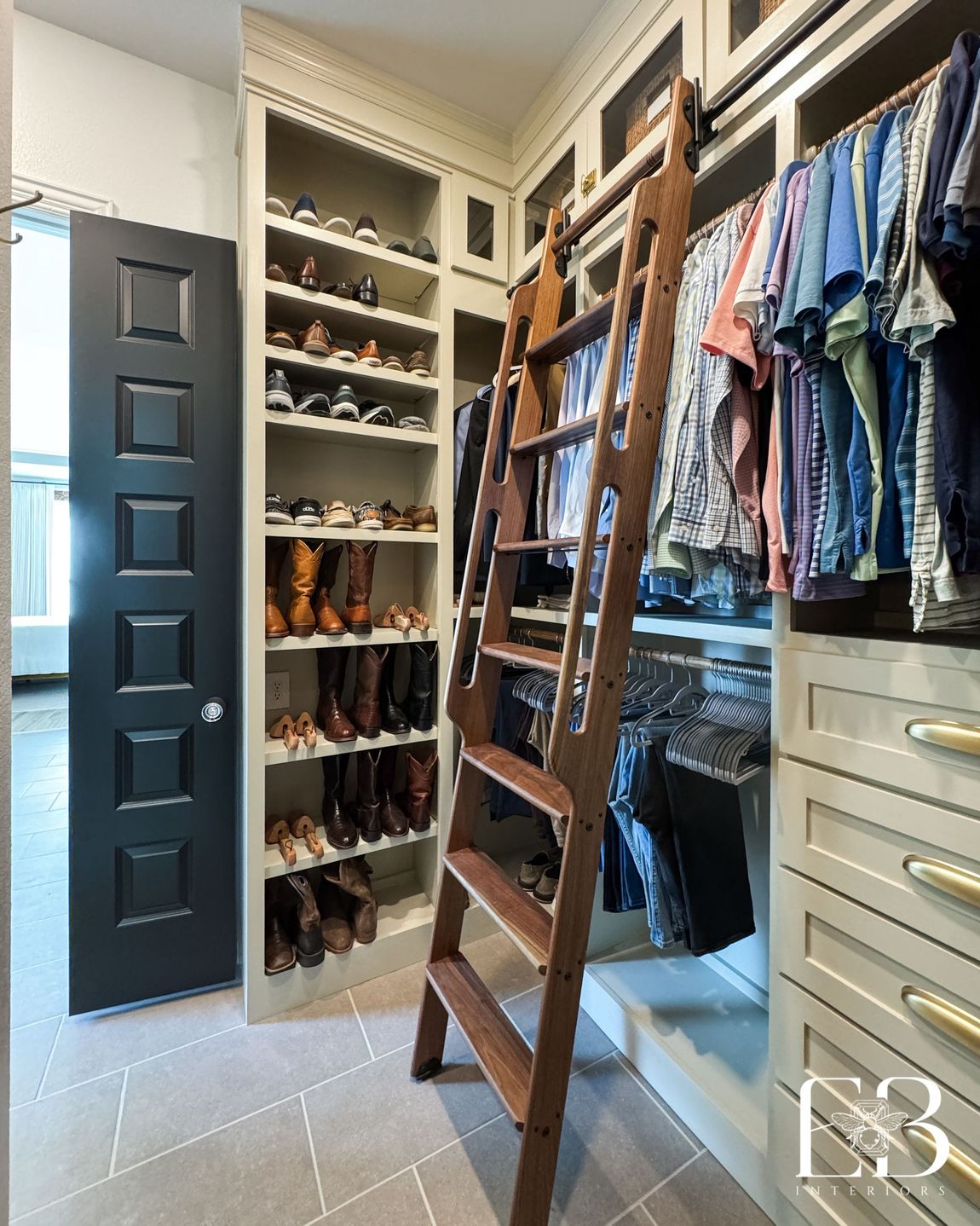 Walk-in closet with rolling ladder, custom shoe shelves, and baskets by Emerald Bee Interiors for the Devotion Row home.