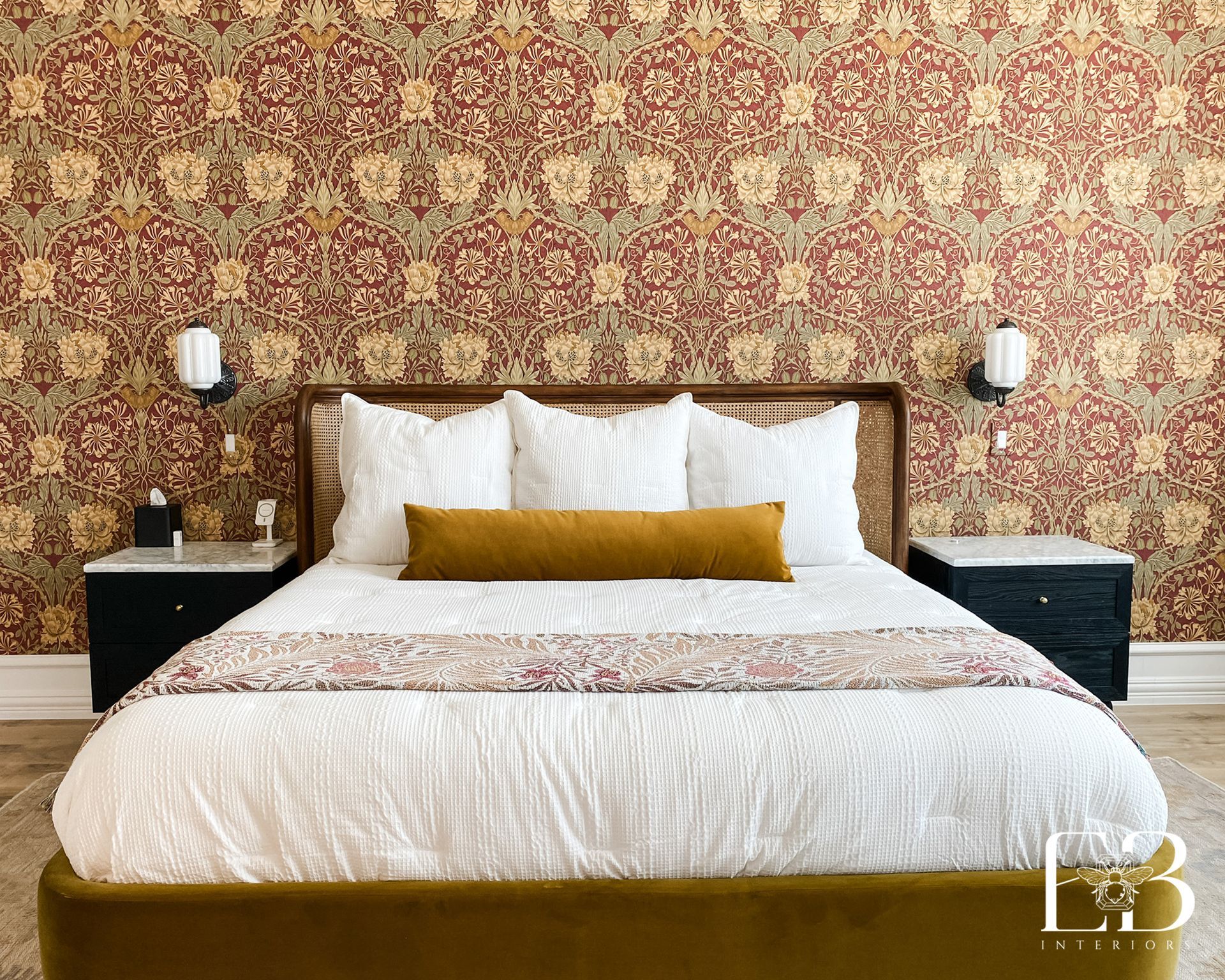 Bedroom with patterned wallpaper, bed with white bedding, and two black nightstands.