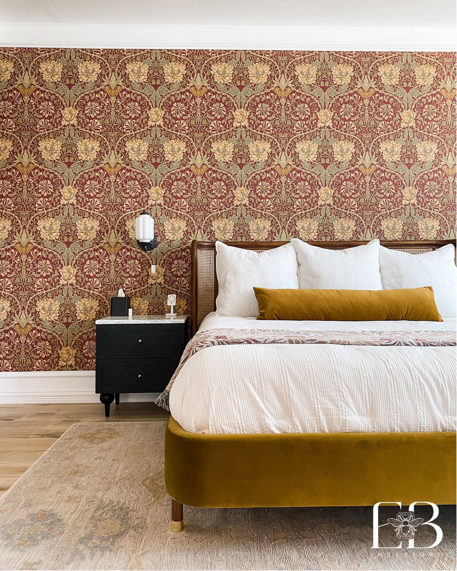 Bedroom with floral wallpaper, mustard bed, black nightstand, white bedding, and a shag rug.