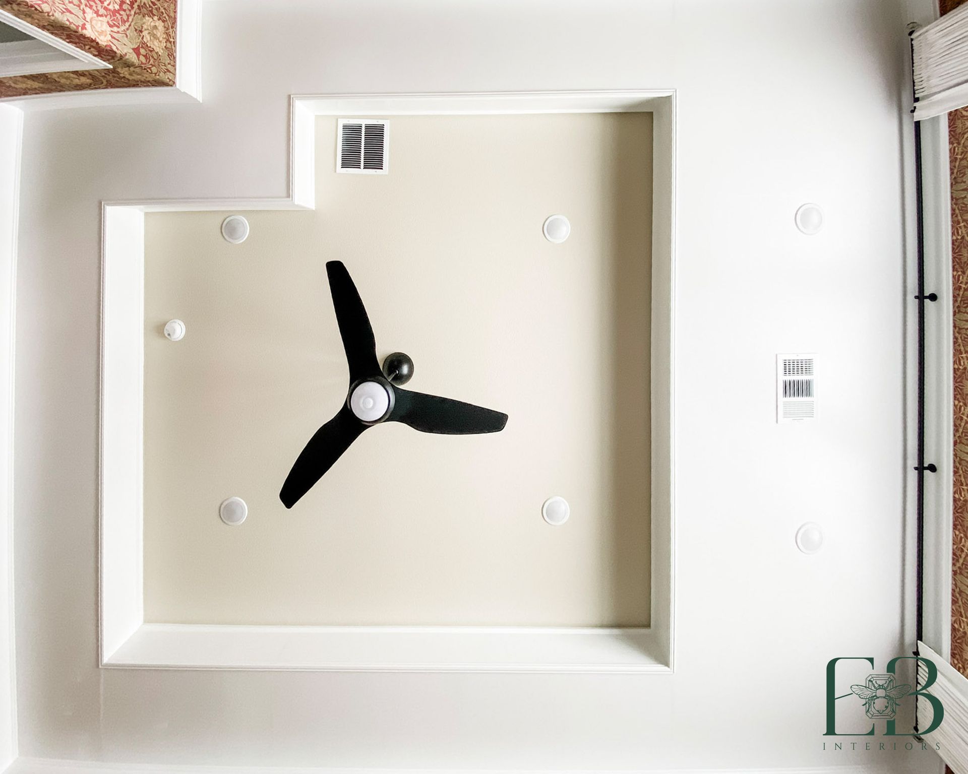 Ceiling with recessed lights, a black ceiling fan, and ventilation grates.