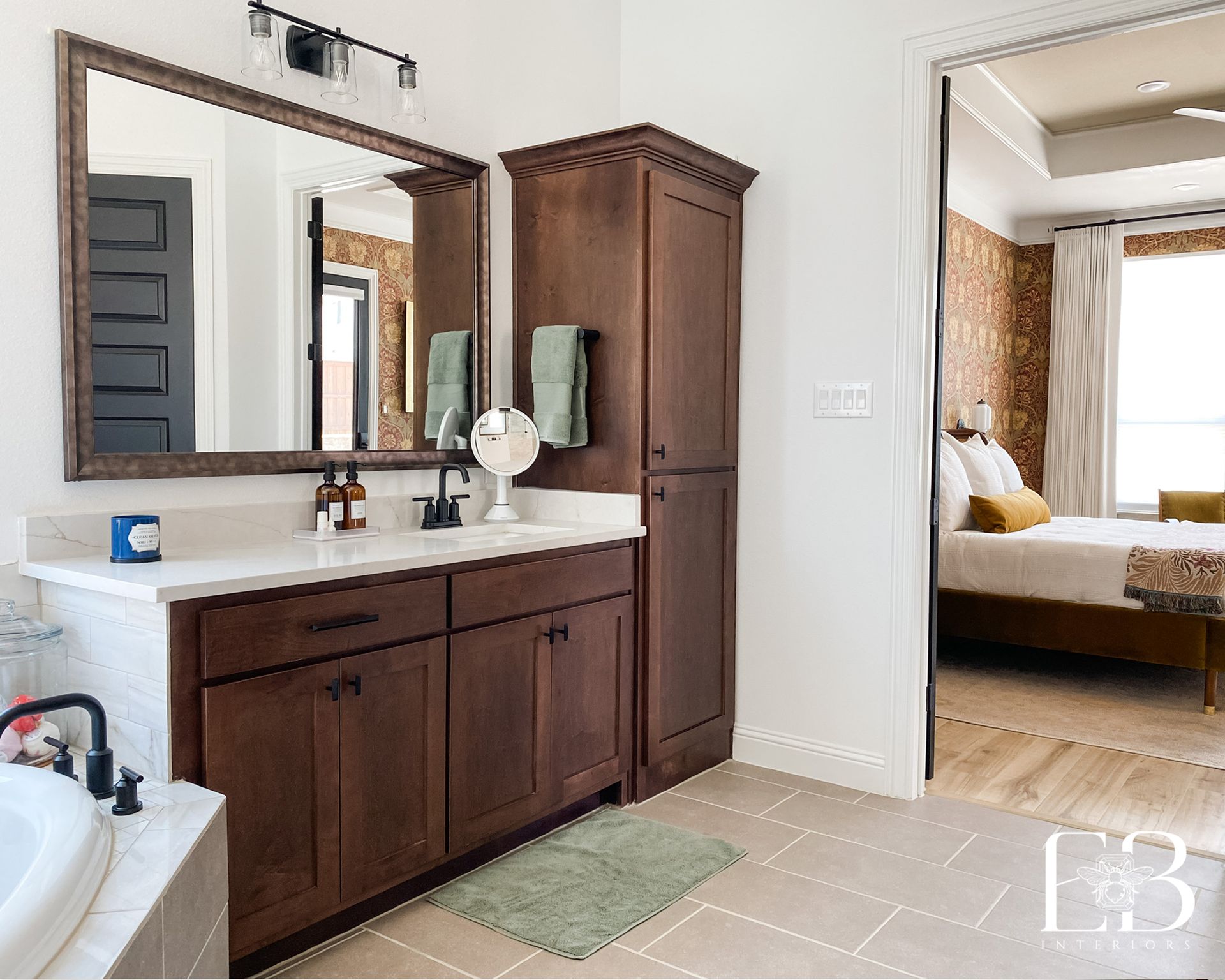 Bathroom with dark wood vanity, large mirror, and open doorway to bedroom.