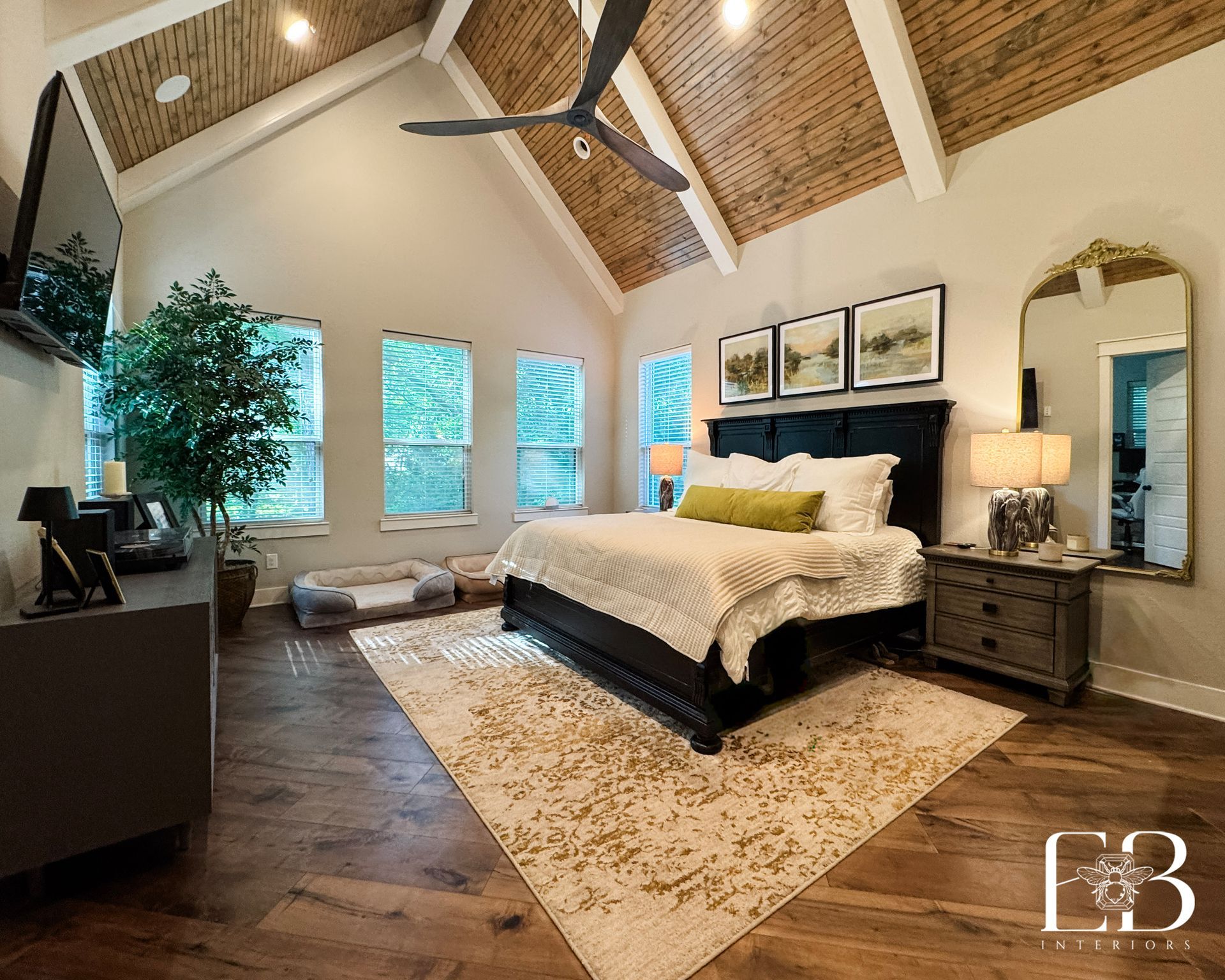 Bedroom with floral wallpaper, black doors, and a bed with white bedding and a cane headboard.