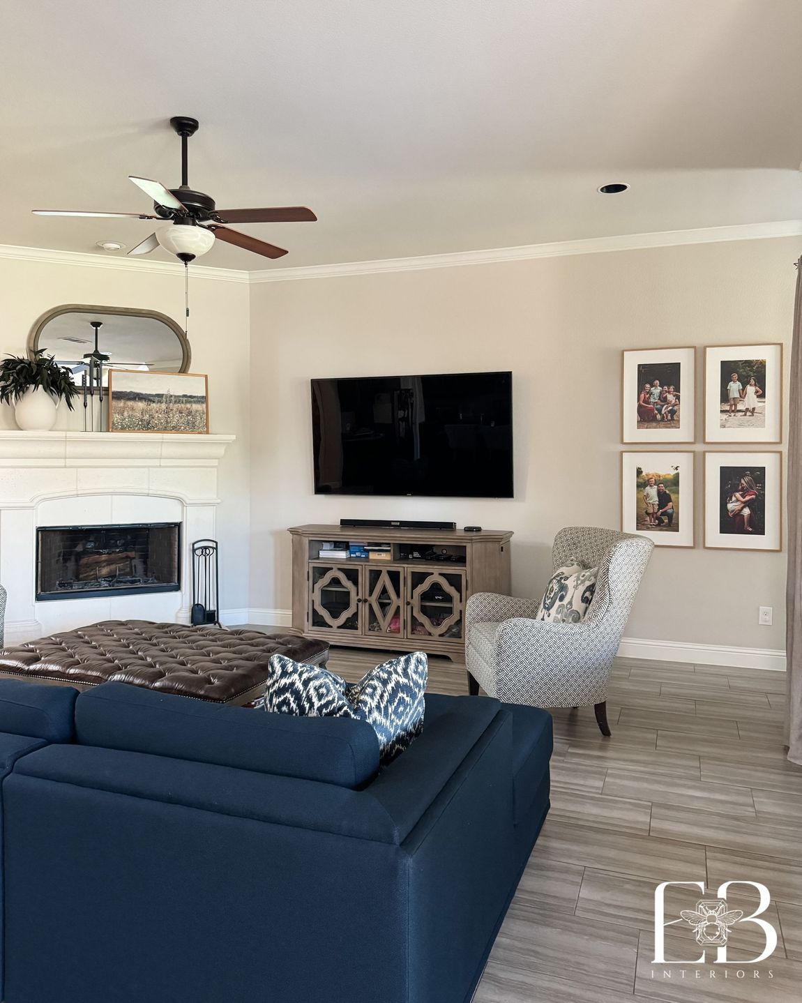 Living area with corner fireplace, navy sectional, and galley wall designed by Emerald Bee Interiors for Spanish Oak Trail.