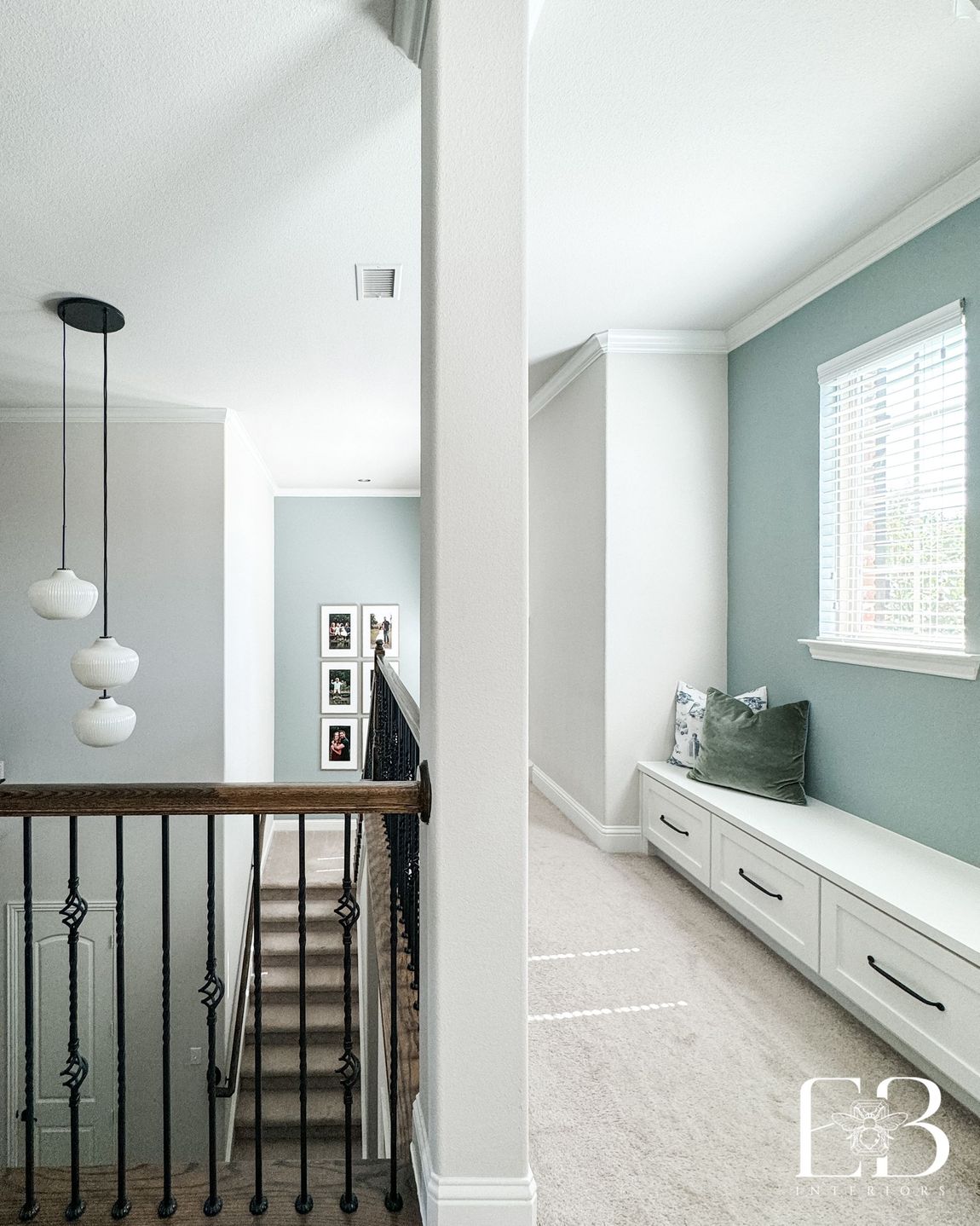 Upstairs hallway and reading nook with built-in drawers, gray accent, and tiered pendant lighting by Emerald Bee Interiors.