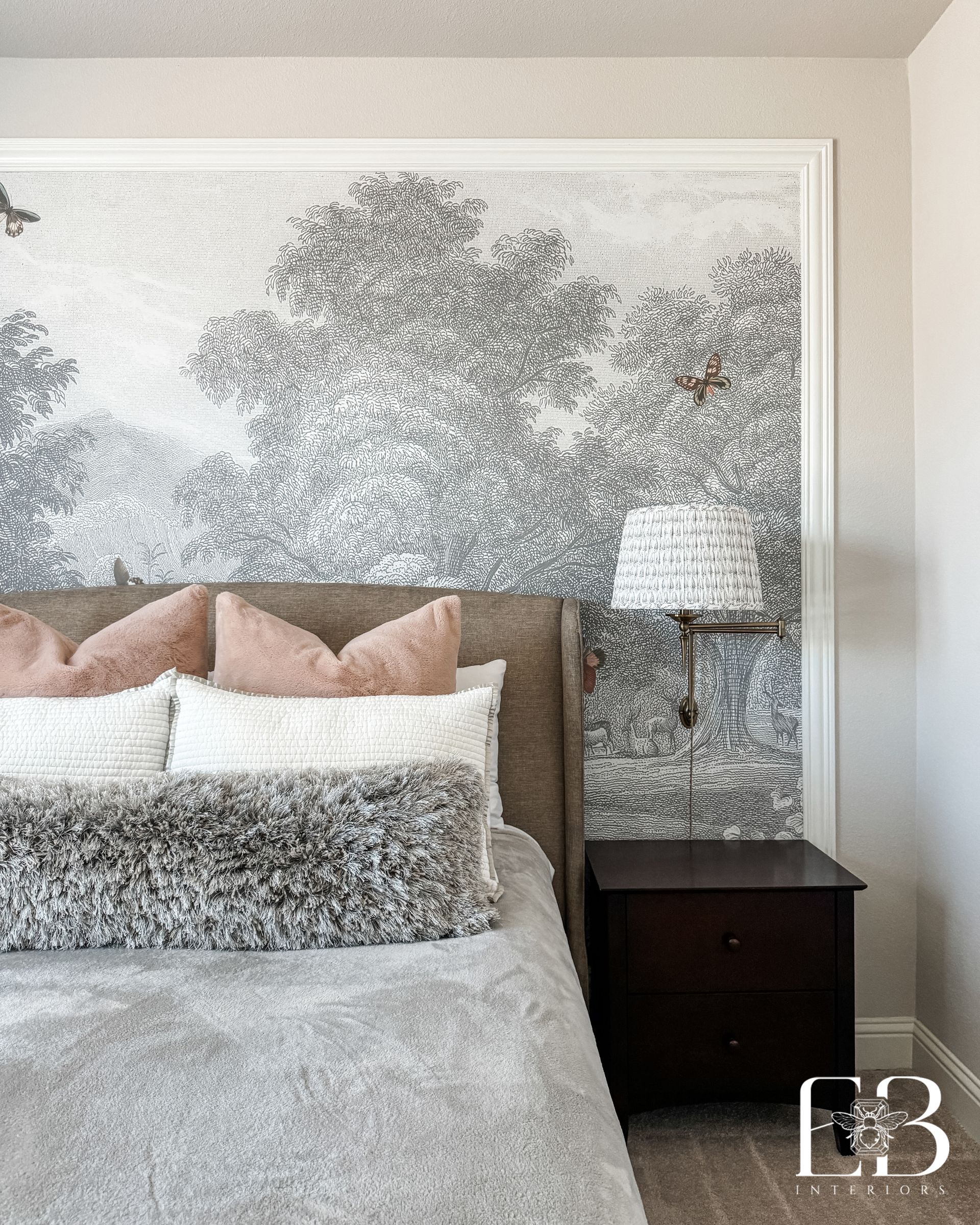Guest bedroom with tonal mural wallpaper, velvet headboard, and layered neutral bedding designed by Emerald Bee Interiors.