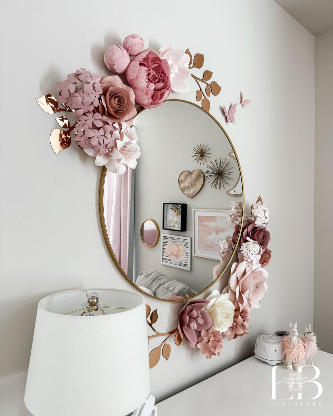 Close-up of round mirror with layered paper flowers in blush and rose tones—styled by Emerald Bee Interiors.