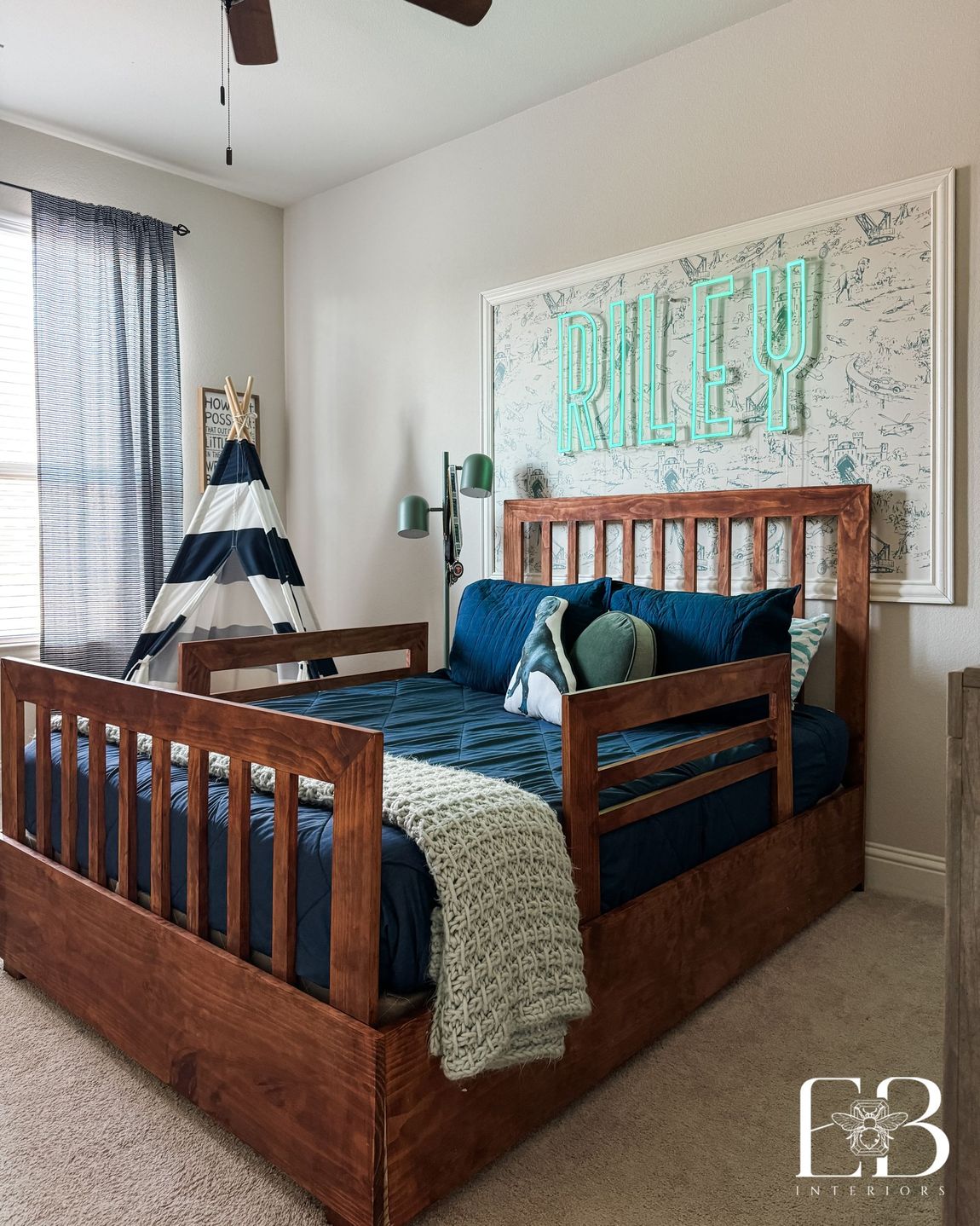 Boy’s bedroom featuring custom wood daybed, striped tent, and framed neon name sign—designed by Emerald Bee Interiors.