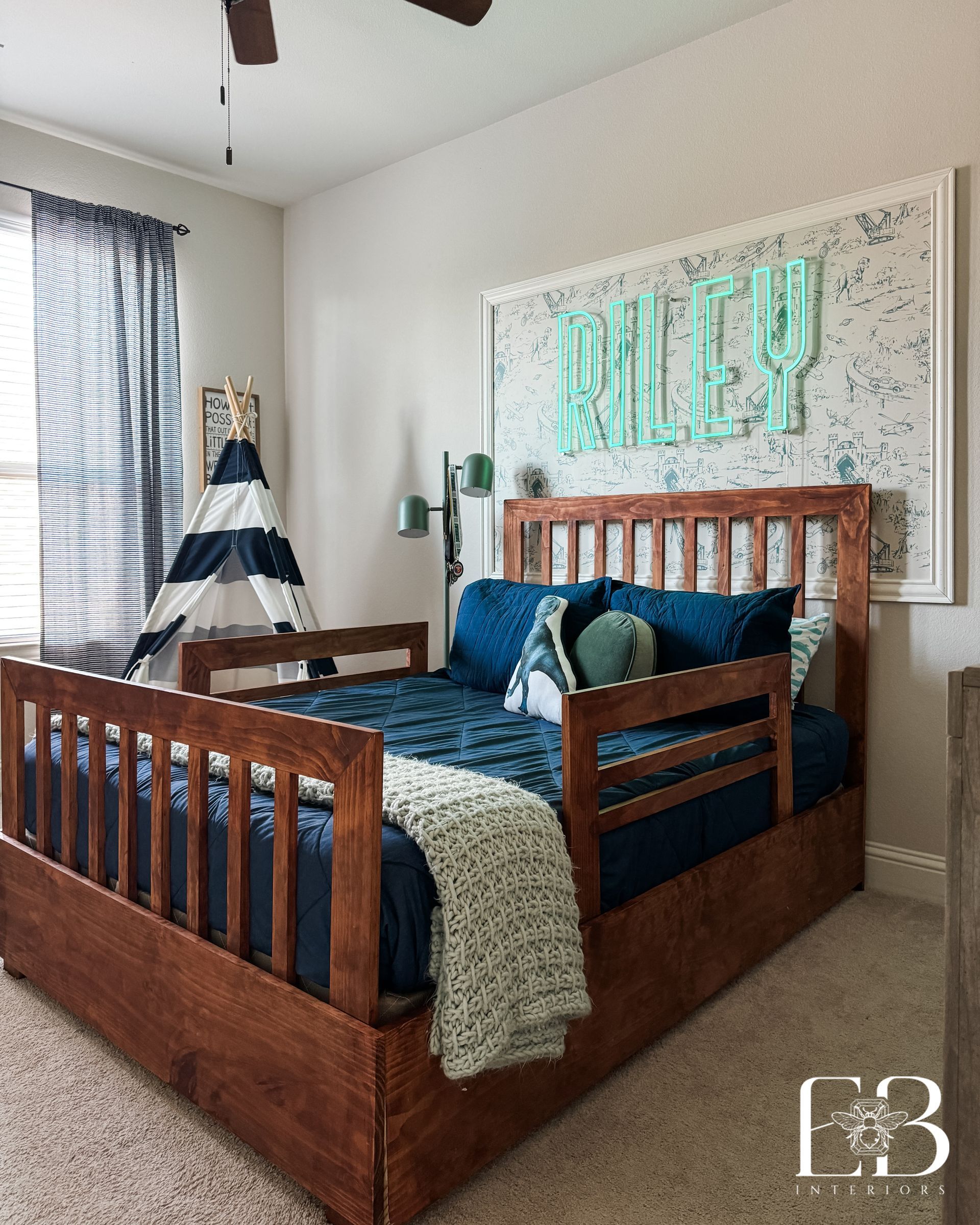 Boy’s bedroom featuring custom wood daybed, striped tent, and framed neon name sign—designed by Emerald Bee Interiors.
