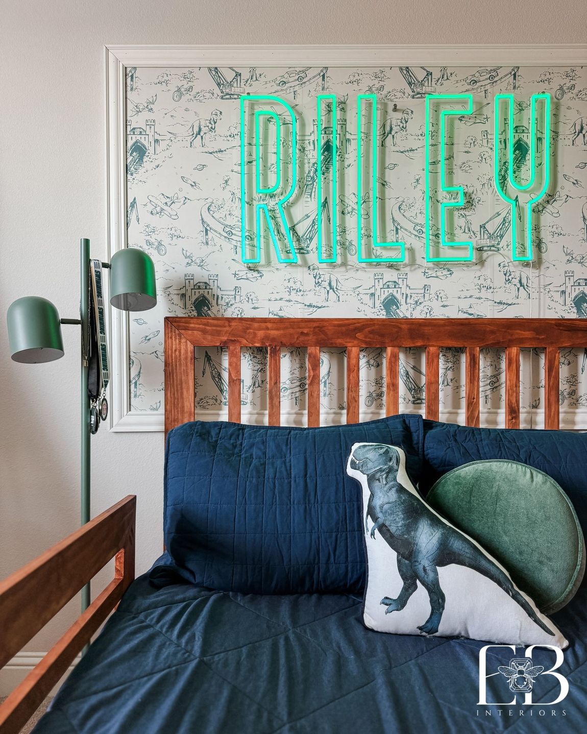 Boys’ bedroom with neon name sign, dinosaur pillow, and navy bedding by Emerald Bee Interiors for Spanish Oak Trail.
