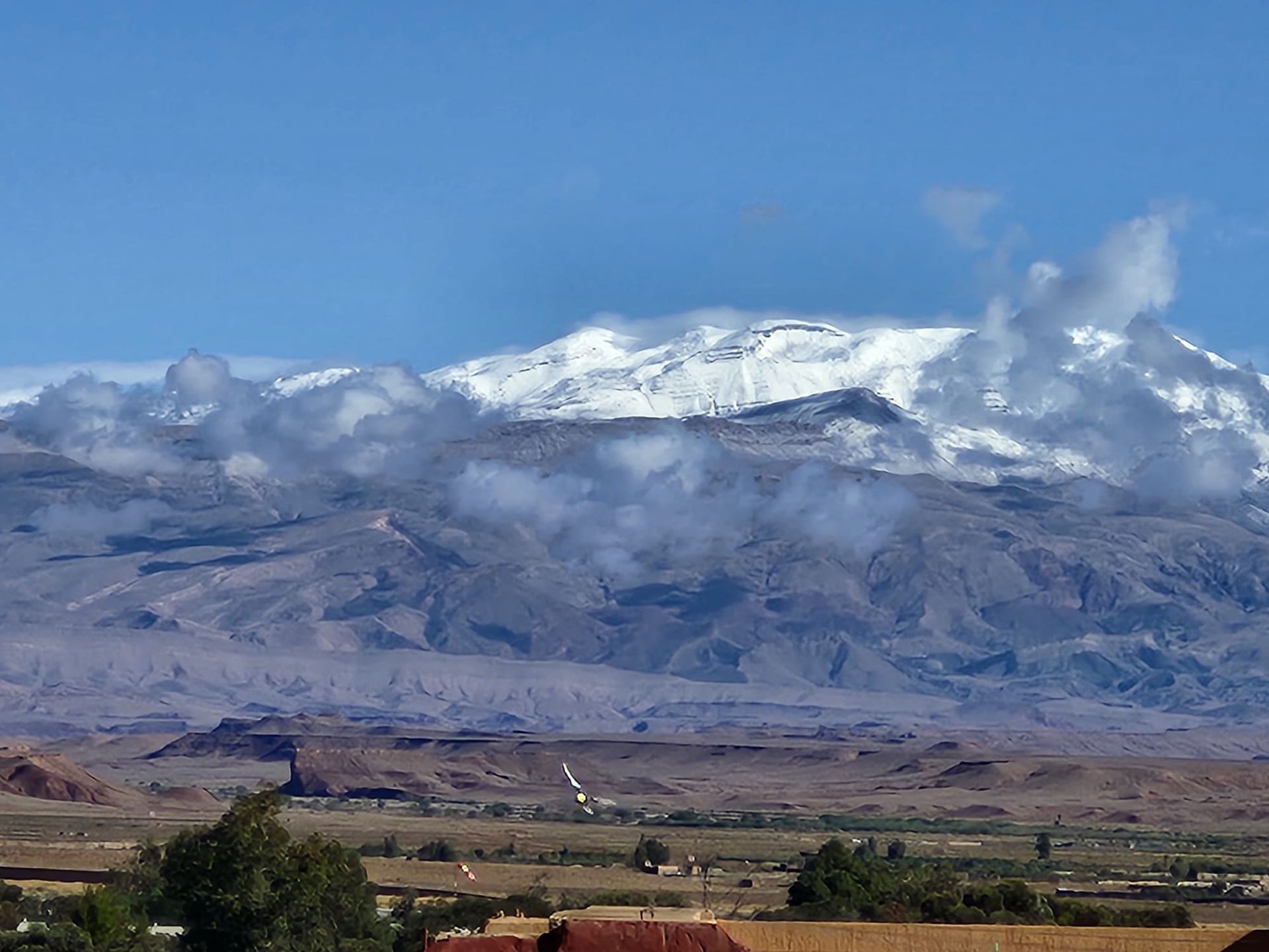 A snowy mountain covered in clouds is visible in the distance