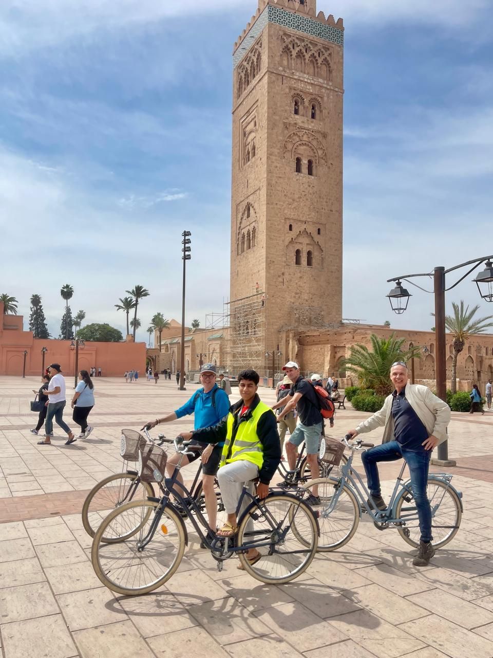 A group of people are riding bicycles in front of a tower
