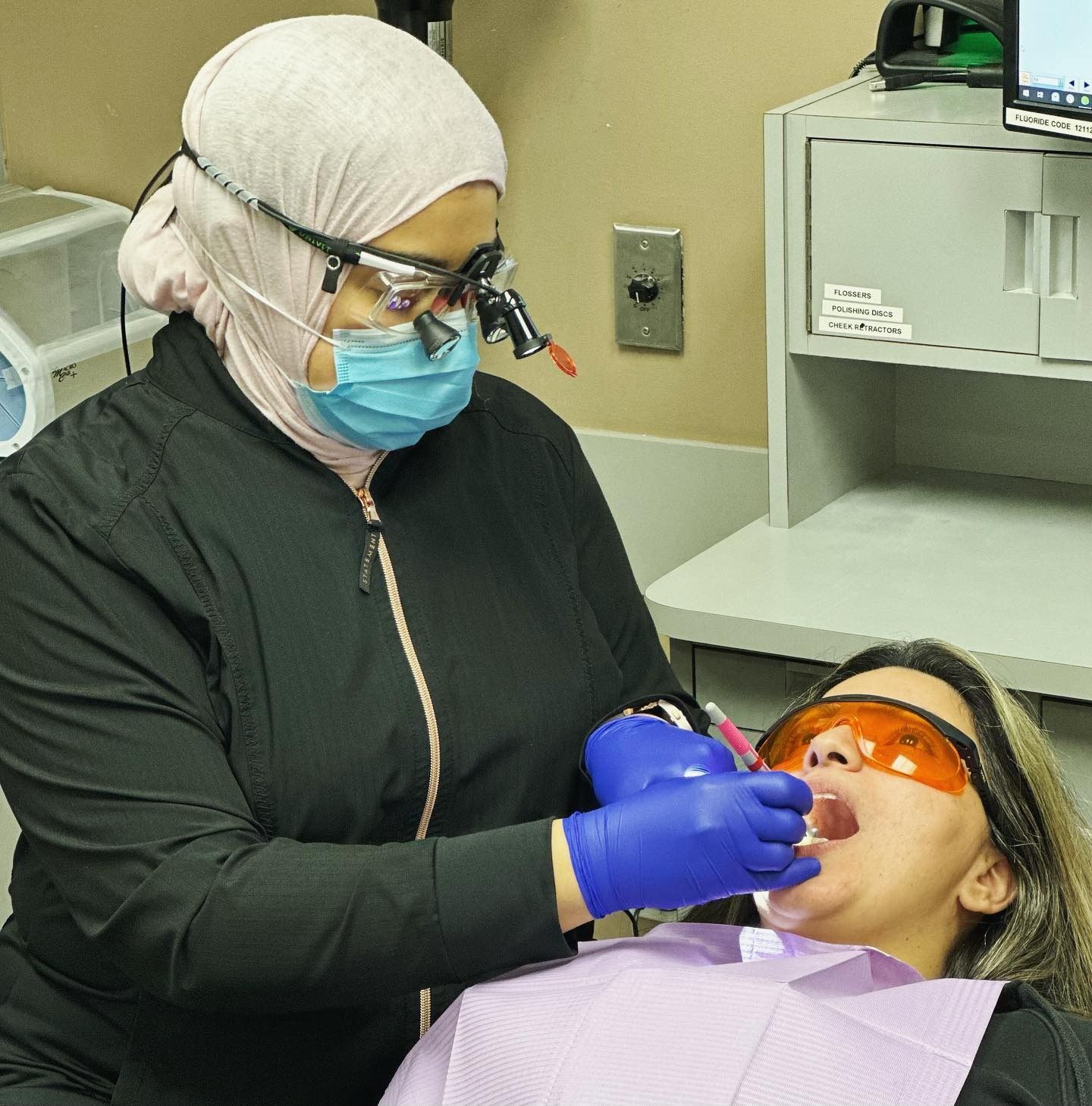 A woman is getting her teeth examined by Dr. Nermeen El Gamma