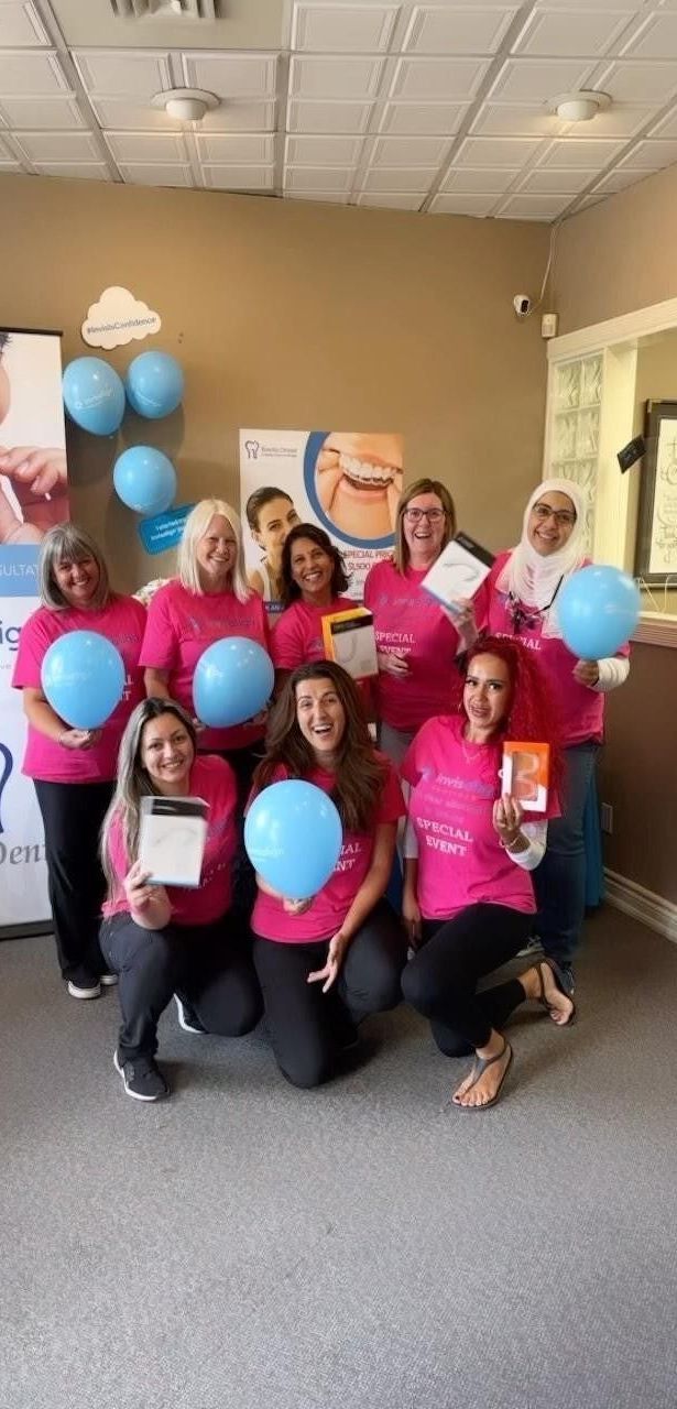 A group of women are posing for a picture while holding blue balloons.