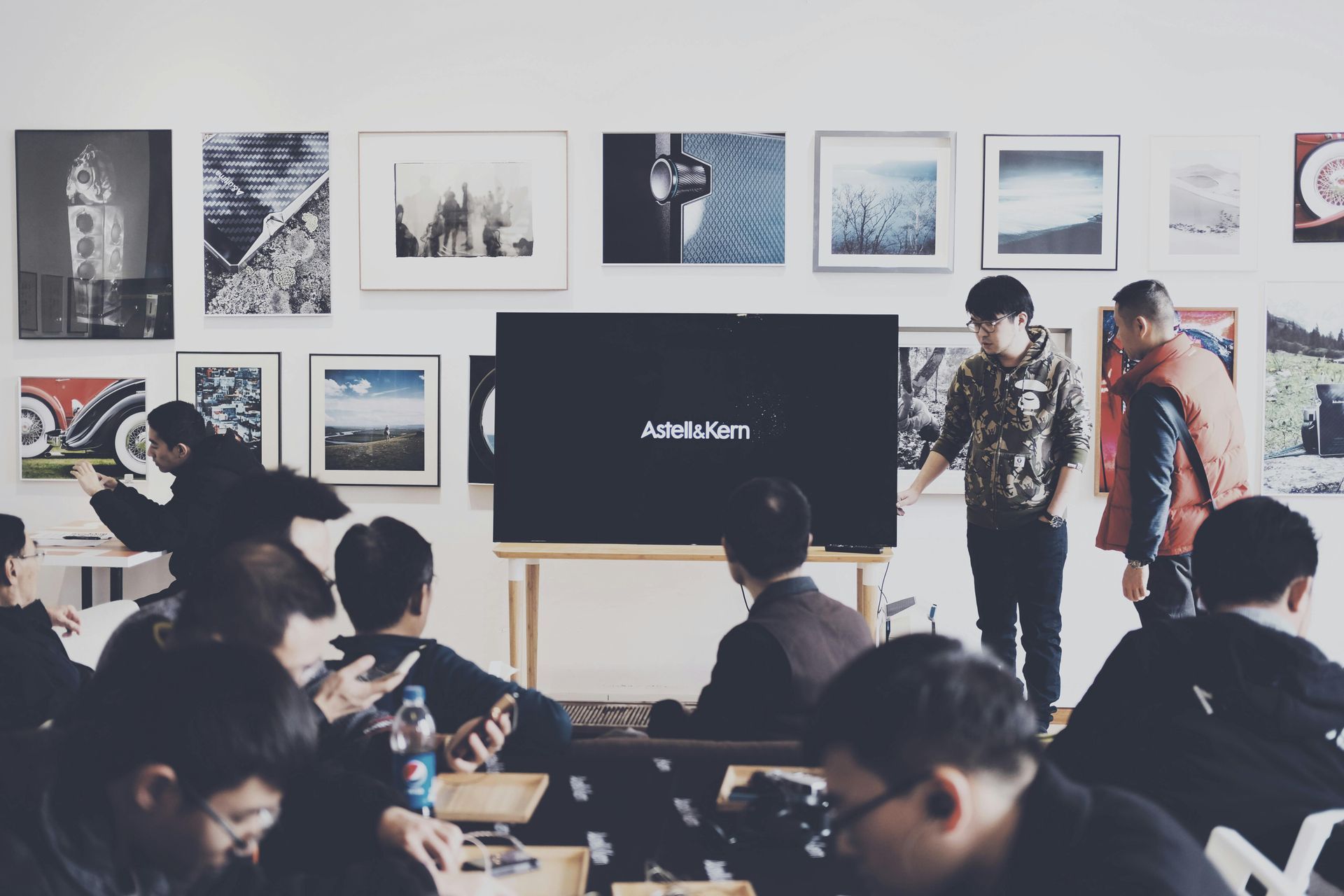 A group of people are sitting in front of a large screen.
