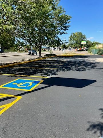 A handicapped parking spot in a parking lot with trees in the background.