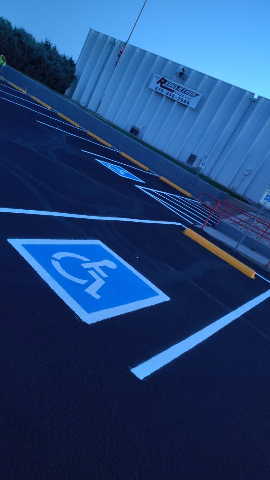 A handicapped parking spot in a parking lot with trees in the background.