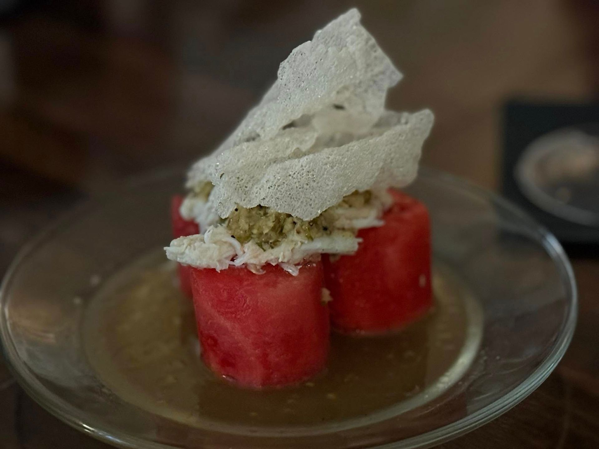 A glass plate topped with watermelon slices and whipped cream.