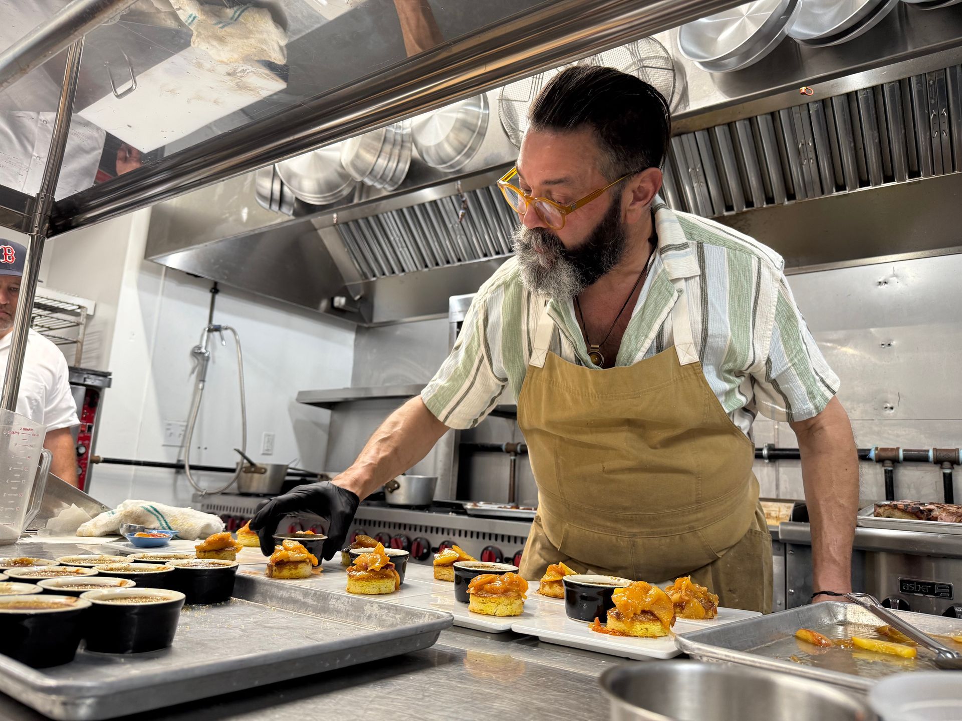 A man in an apron is preparing food in a kitchen.