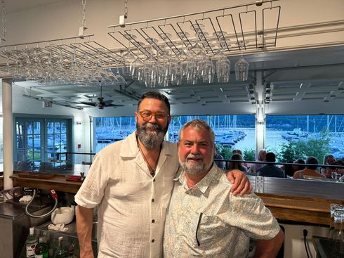Two men are posing for a picture in a restaurant.