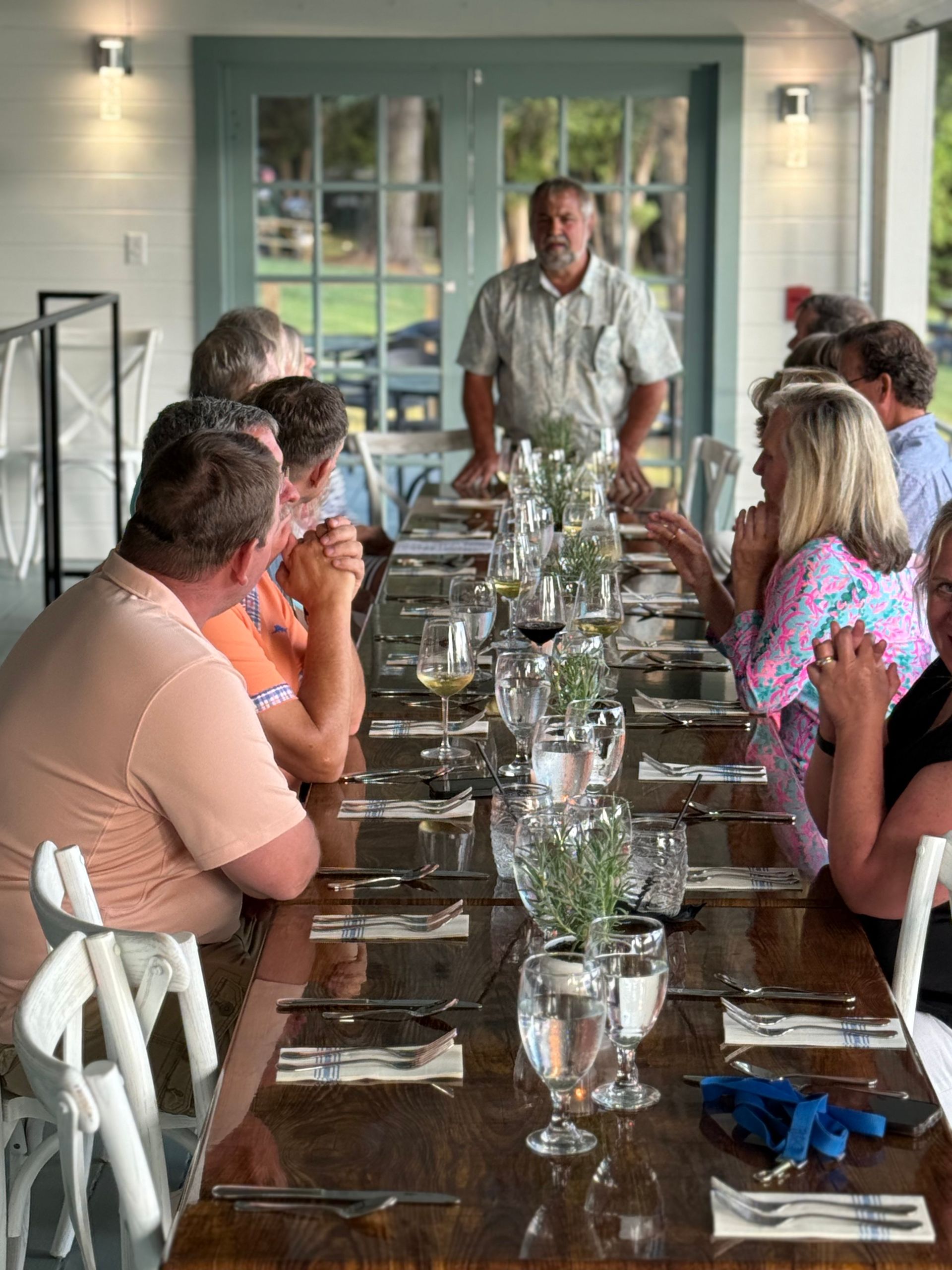 A group of people are sitting at a long table in a restaurant.