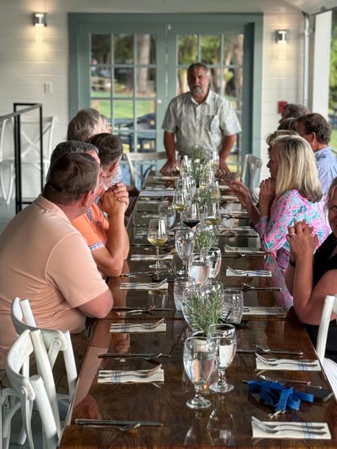 A group of people are sitting at a long table in a restaurant.