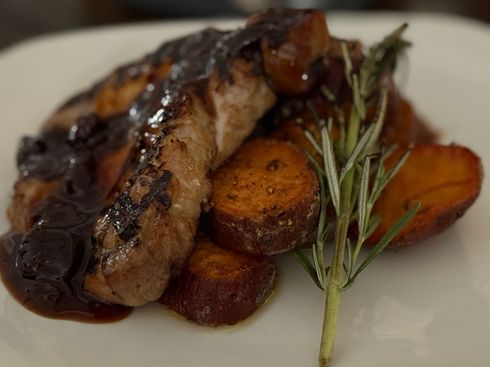 A close up of a plate of food with meat and potatoes on a table.