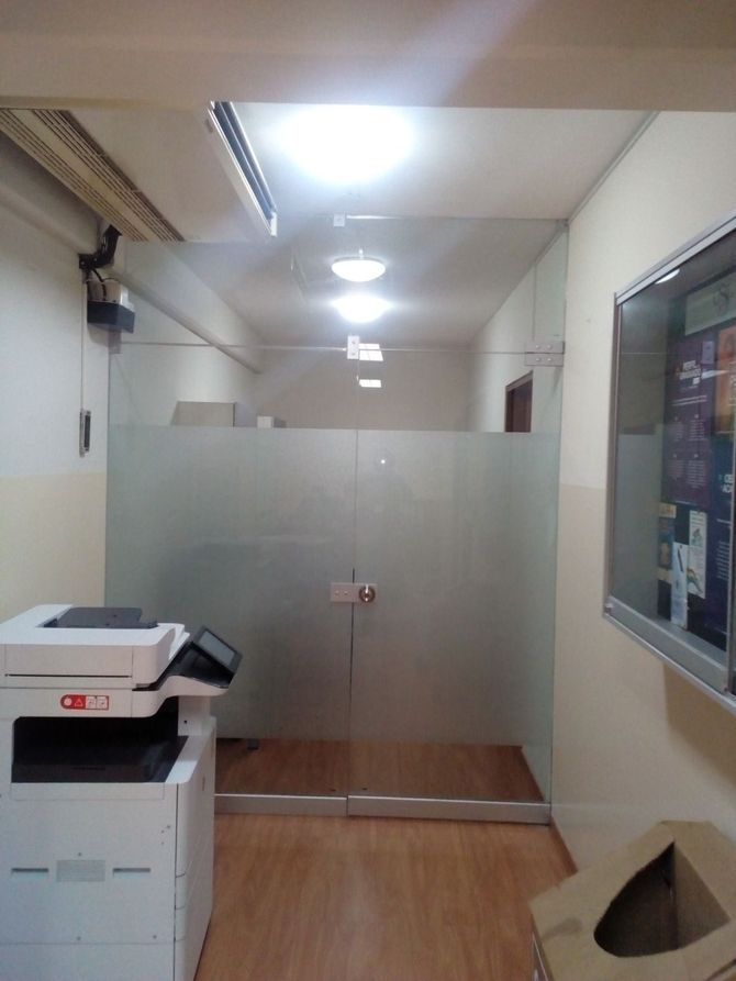 Un edificio blanco de dos plantas con una fachada superior de color rojo brillante, balcones en las esquinas y la bandera colombiana ondeando en la fachada principal.