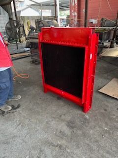 Red industrial radiator in a workshop.
