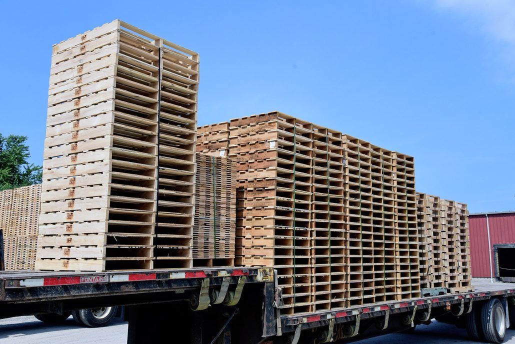 a stack of wooden pallets on top of a semi truck